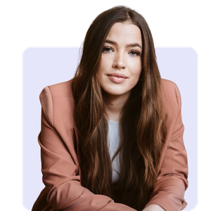Portrait of a young woman with long brown hair wearing a pink blazer.