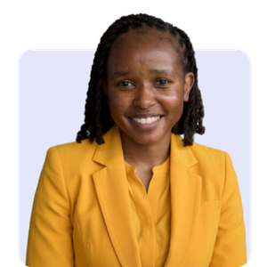 A woman with dark braided hair smiling, wearing a yellow blazer and matching shirt, against a plain background.