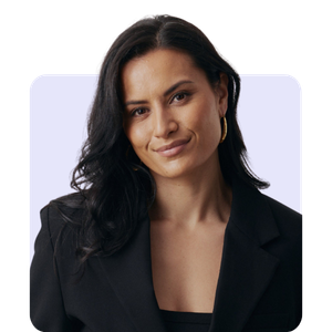 A woman with long dark hair, wearing a black blazer and gold hoop earrings, looking confidently at the camera with a slight smile.