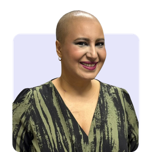 Woman with short hair, smiling, wearing a patterned top.