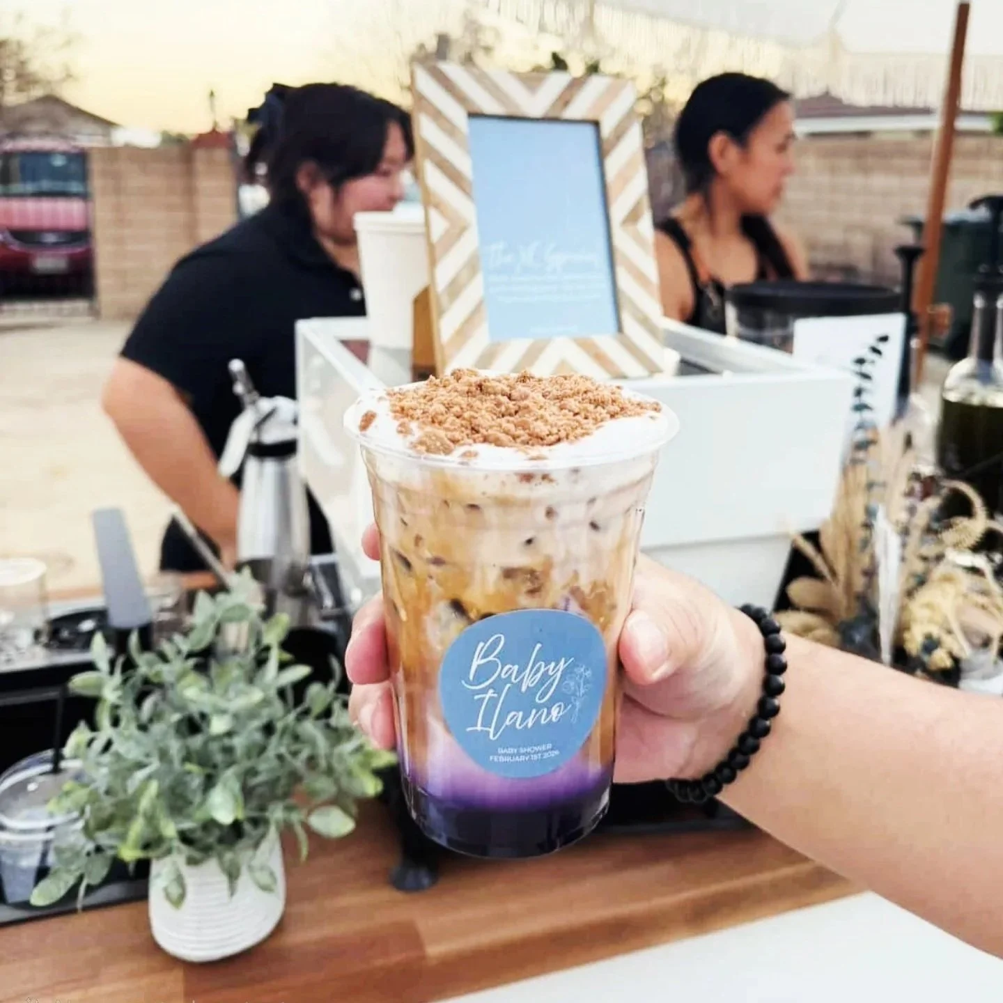 holding signature latte drink at a baby shower