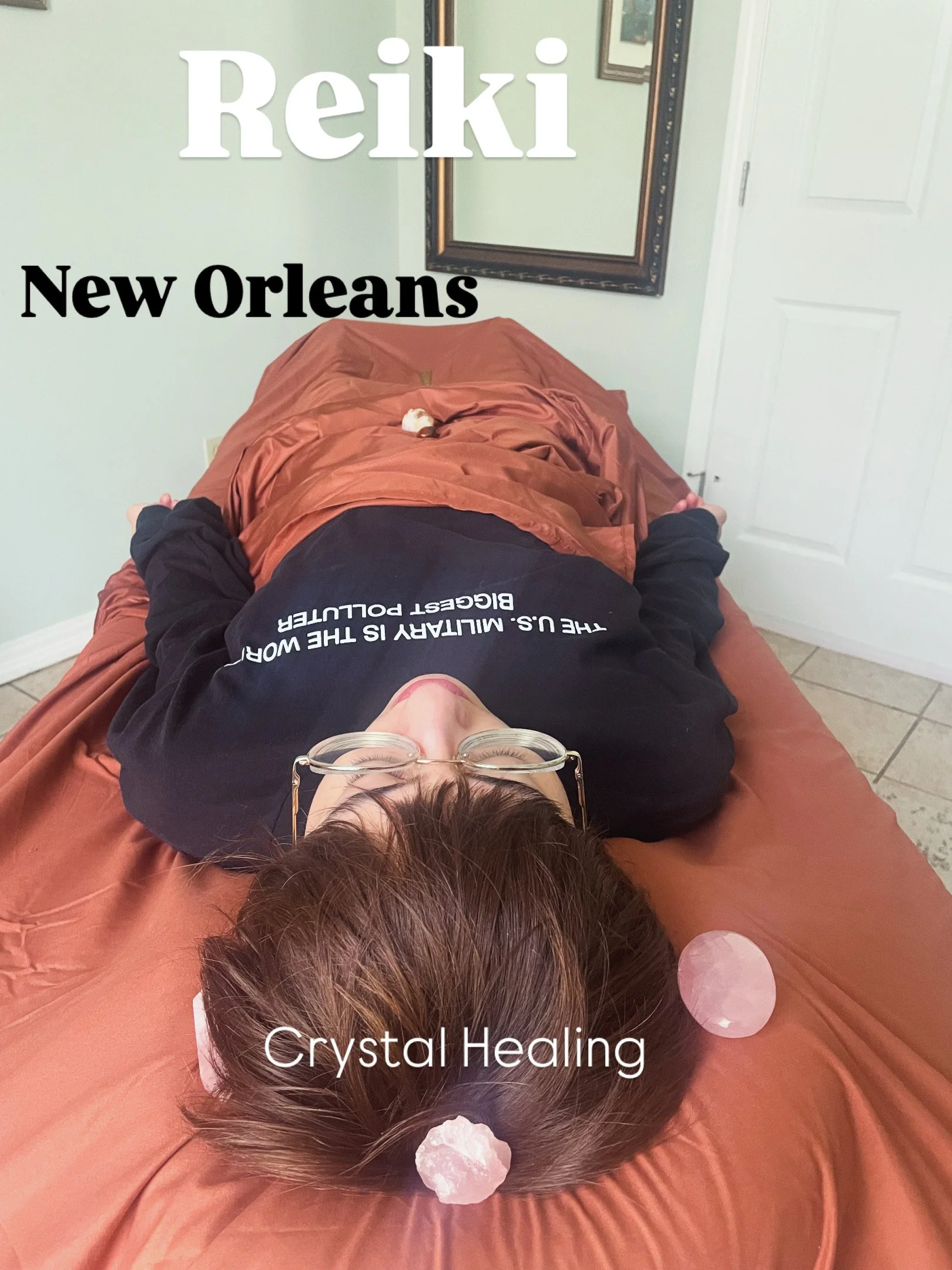 Person lying on a massage table with crystals on her head, labeled 'Crystal Healing,' in a room with a mirror and white door.