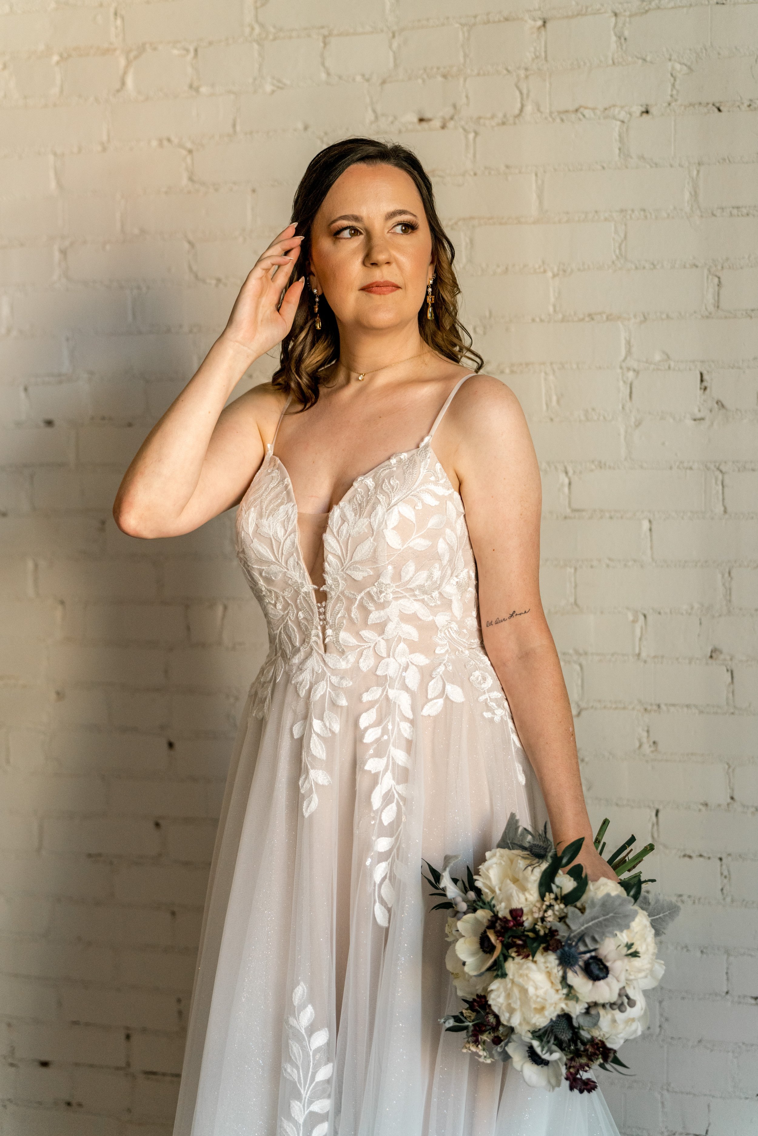 Bride in white floral lace wedding dress holding bouquet