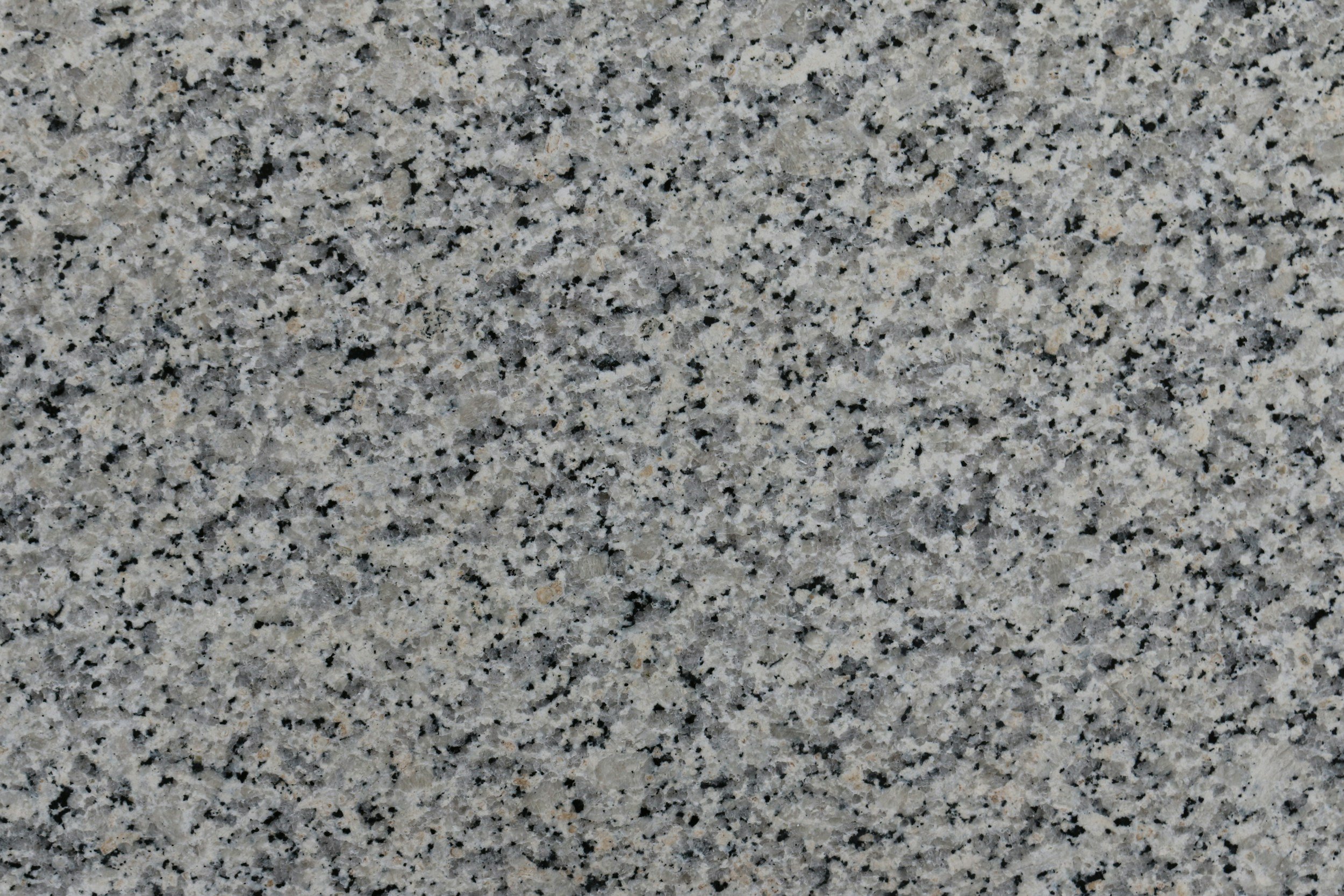 Close-up of a granite countertop with a speckled pattern of black, white, and gray mineral grains.