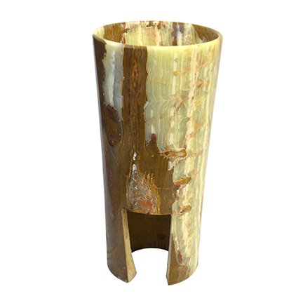 A tall, cylindrical vessel made of polished onyx or similar stone with natural brown, beige, and cream-colored patterns, featuring a cut-out section at the bottom.