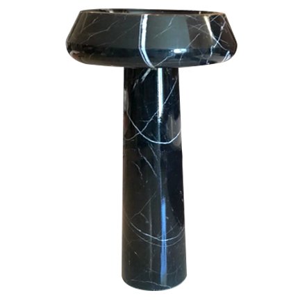 A black marble pedestal with white veining, featuring a rounded top and a cylindrical base.