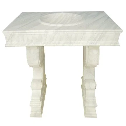 White marble bathroom vanity with a sink cutout and carved pedestal legs.