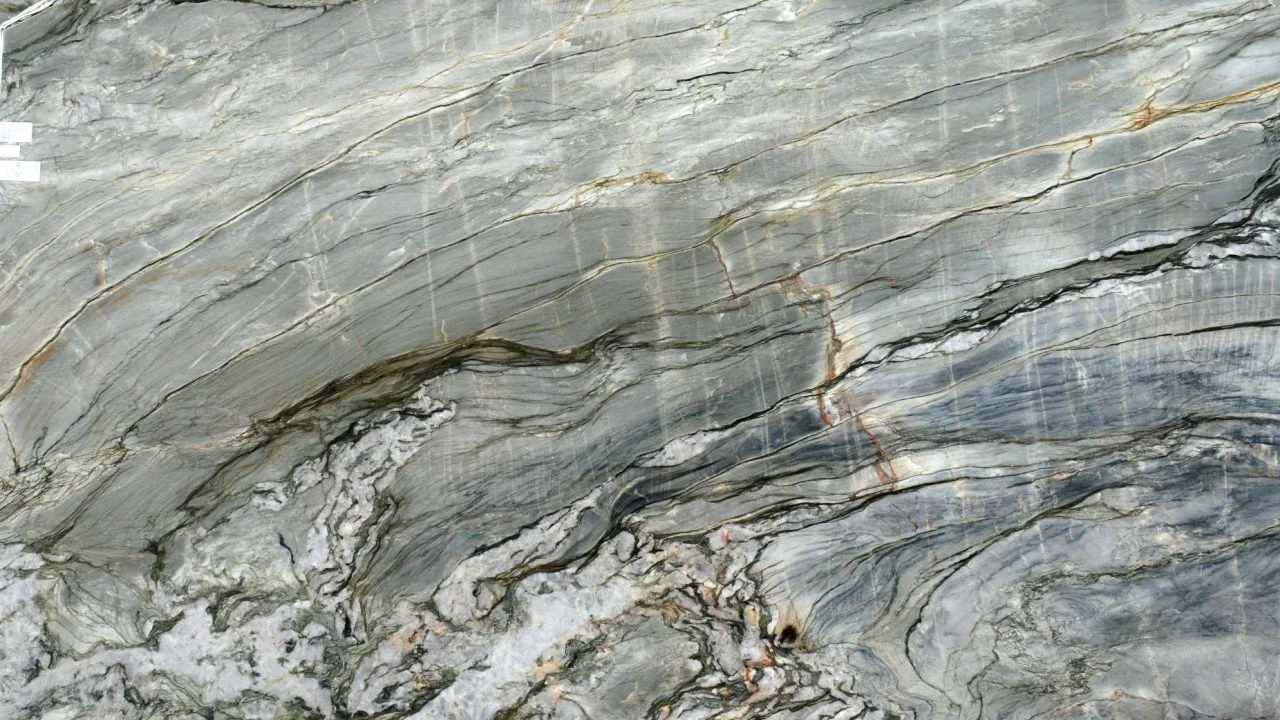 Close-up of a section of gray and beige marble with natural veining patterns.