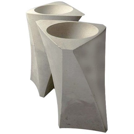 Two modern white concrete planters with geometric shapes and open tops.
