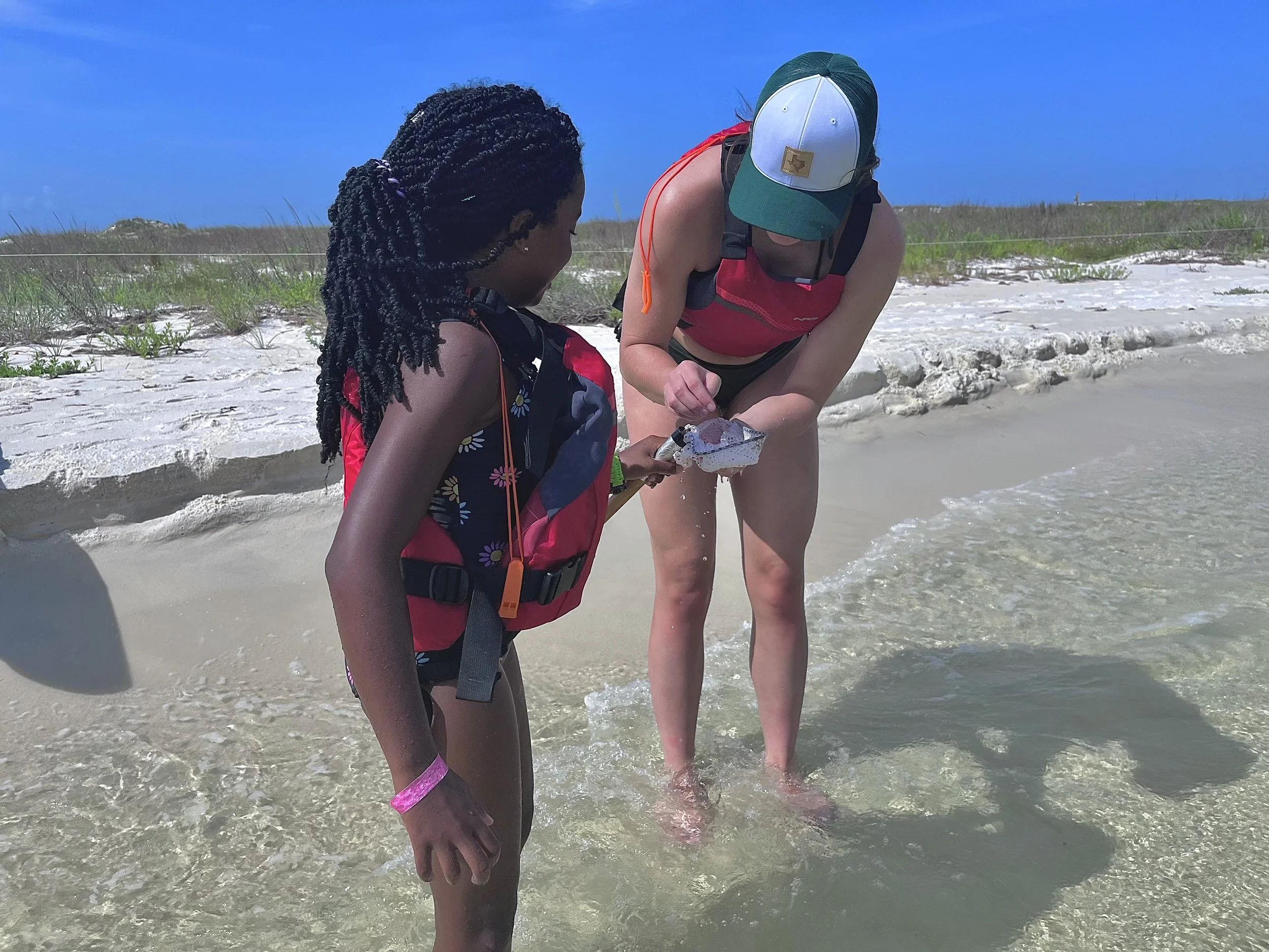 Group kayaking on a narrow river surrounded by dense trees and foliage