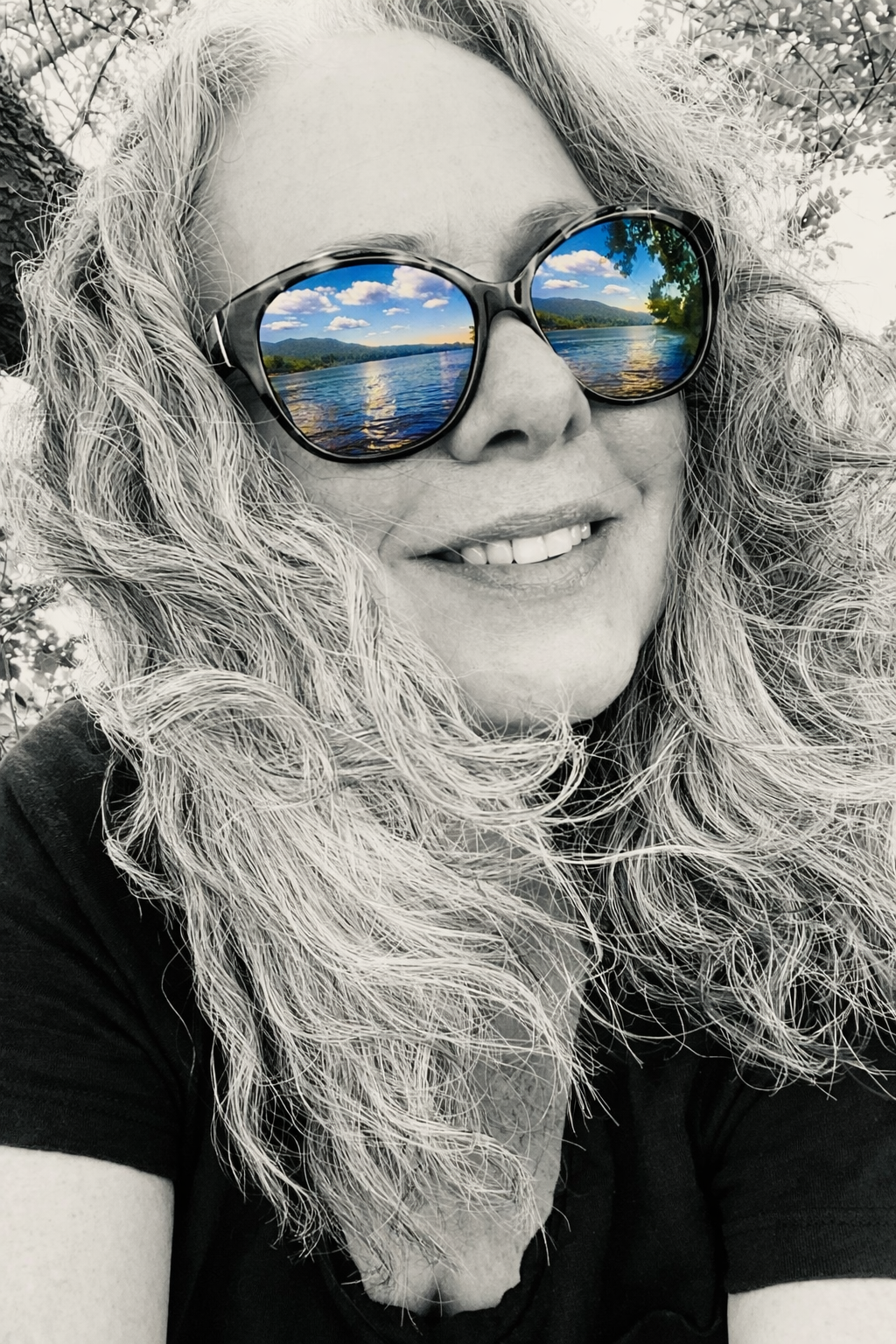 Portrait of interfaith chaplain Rochelle Bayless wearing sunglasses, with the Hudson River reflected in the lenses.