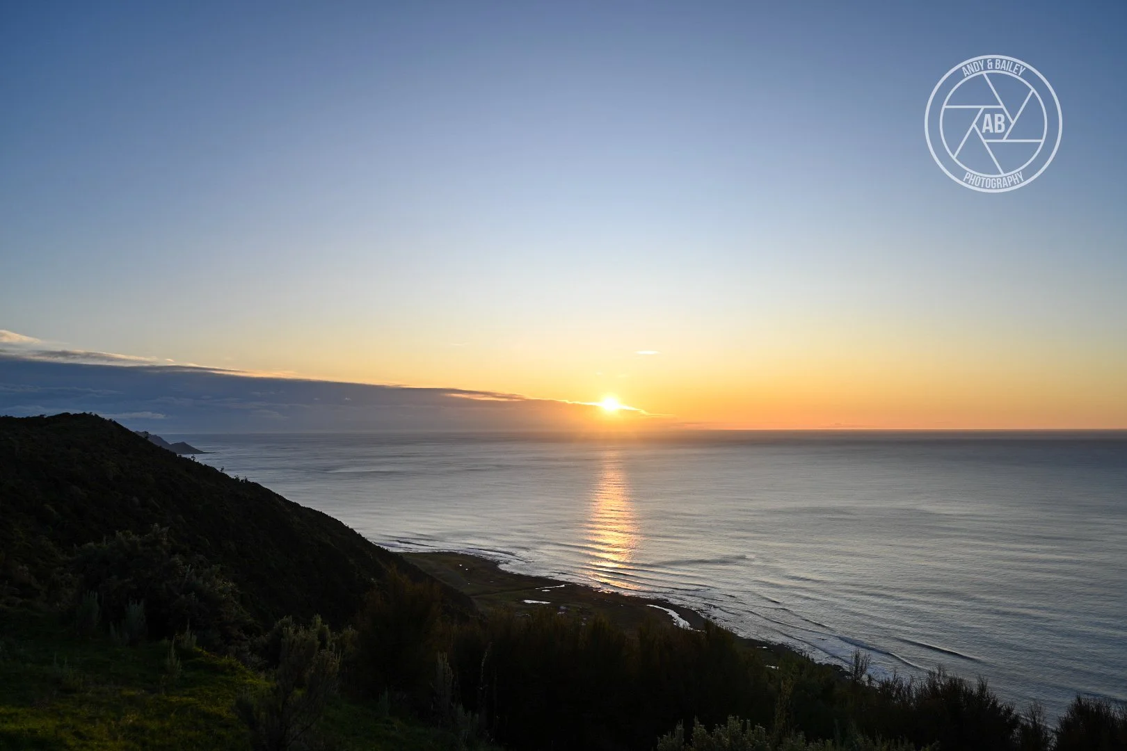 Sunset over the ocean with a clear sky seen from The Last Resort trail, Wairarapa.