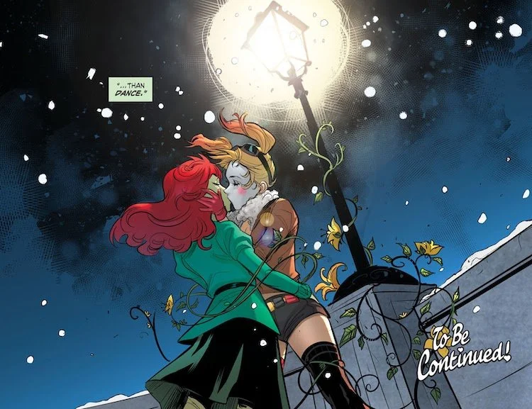 Harley and Ivy kiss in front of a street lamp on a snowy night. They are wearing 40s clothing; Harley's is aviator-inspired.