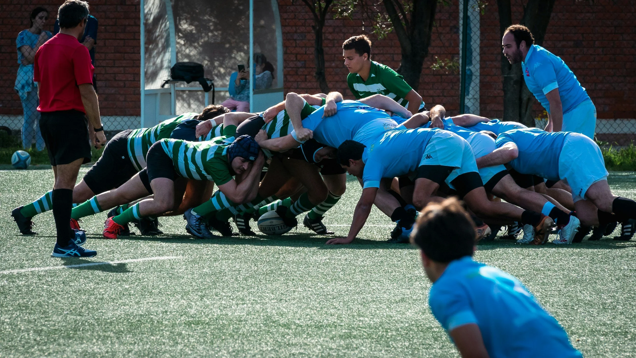 English Rugby players in a scrum during a match on an outdoor field in england