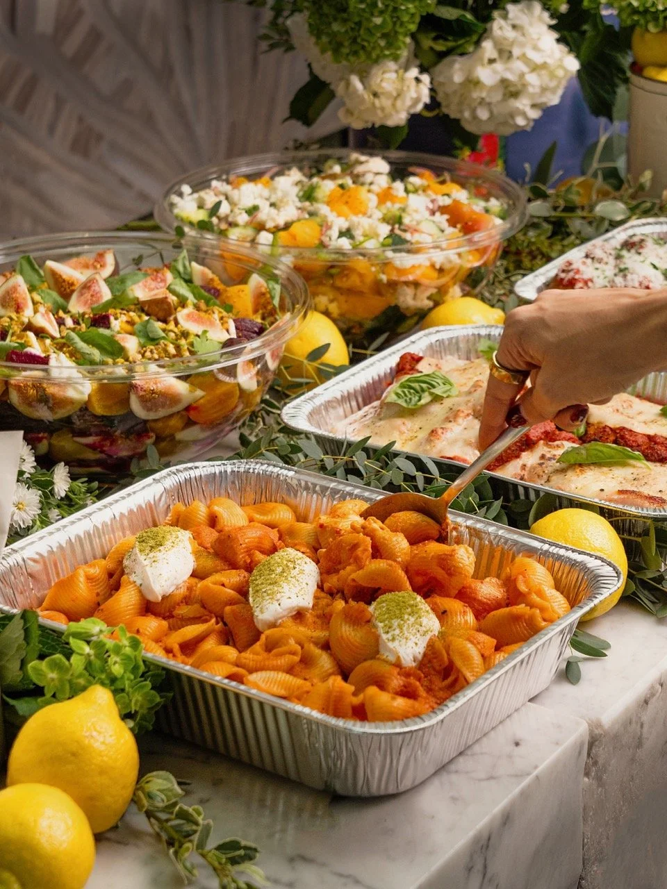 A beautiful spread of Casaléna catering offerings like pasta, salad and chicken parmesan.