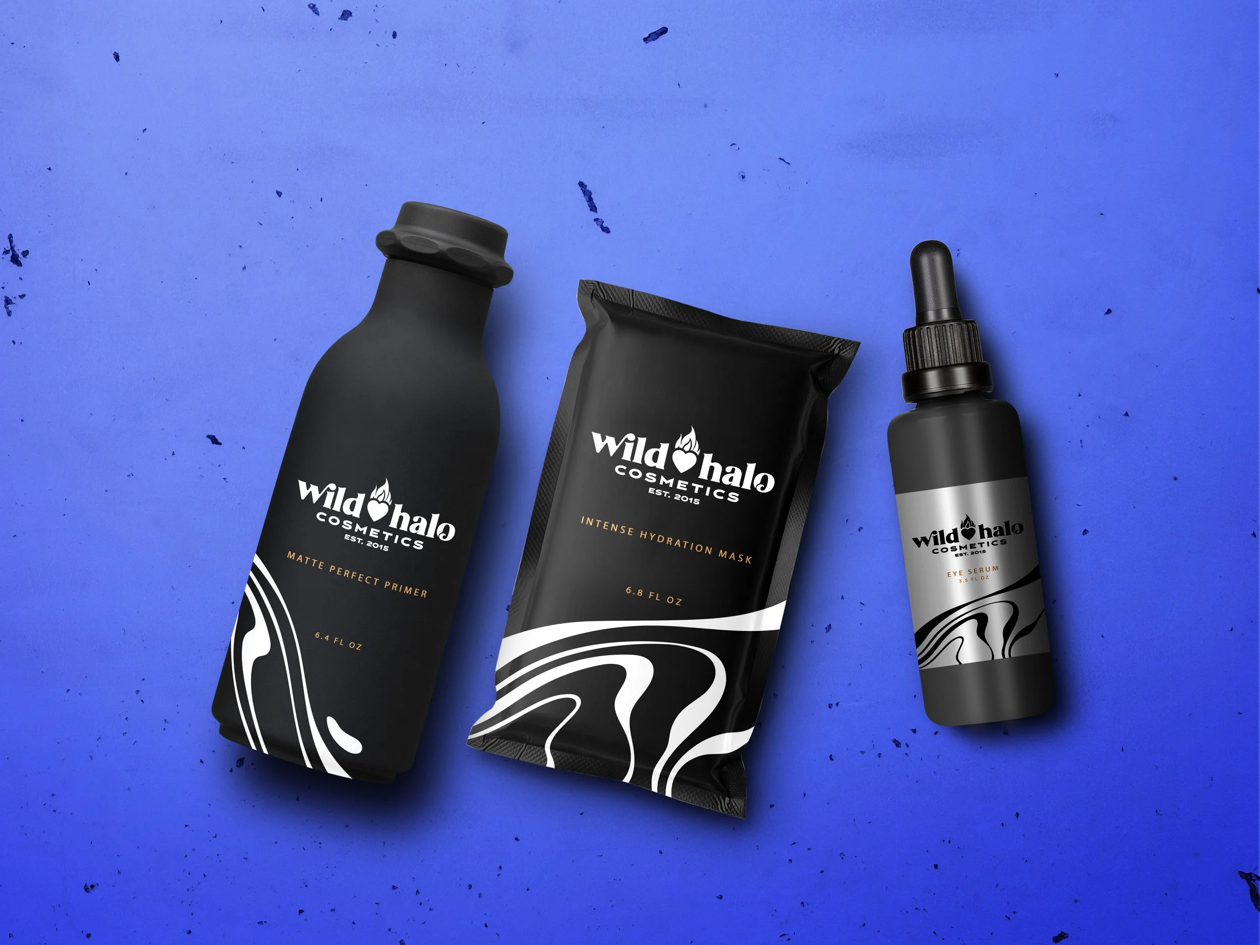 A collection of black Wild Halo Cosmetics products on a blue background, including a matte perfect primer bottle, an intense hydration mask pouch, and an eye serum dropper bottle.