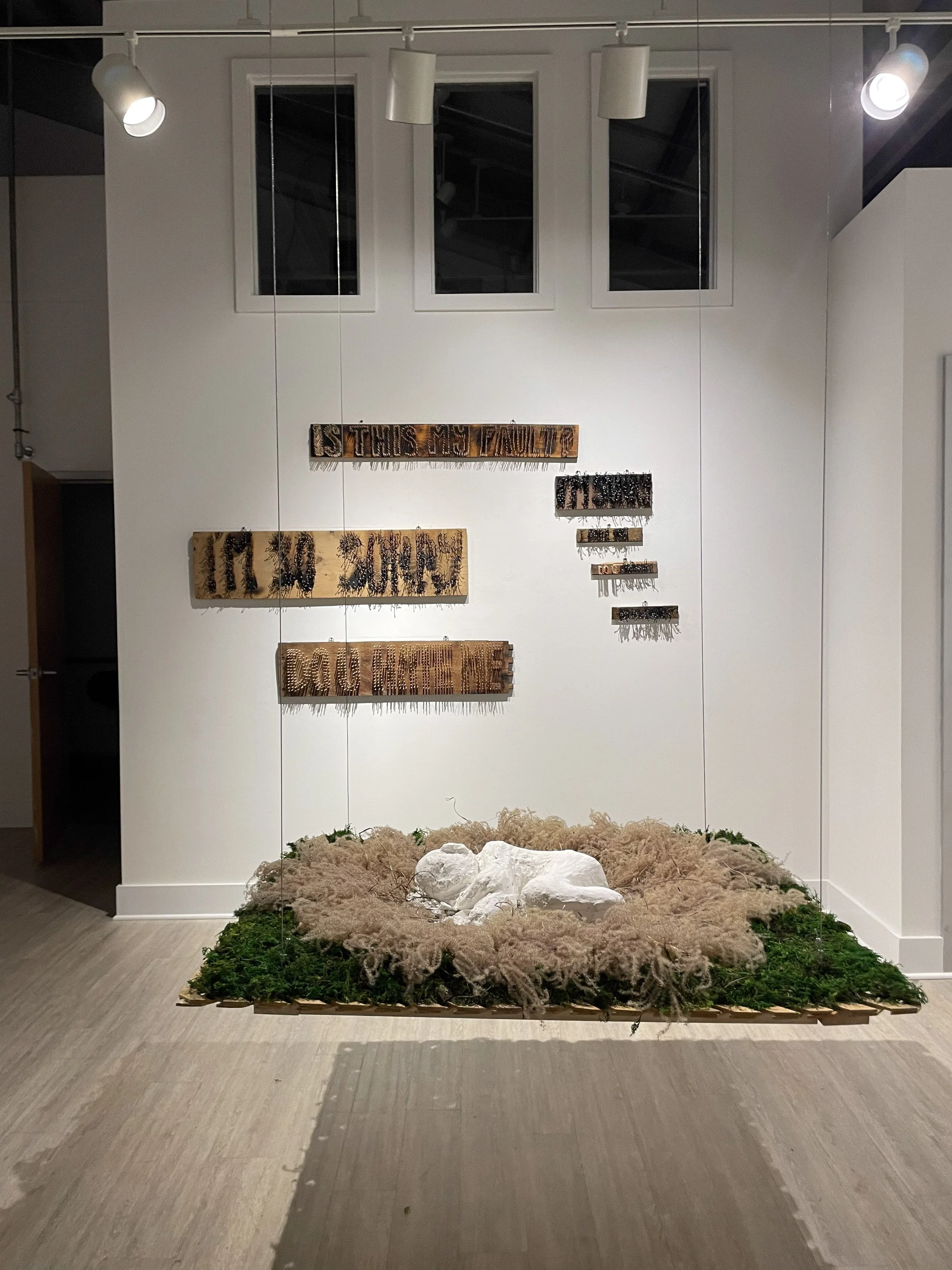 worst case scenario (2024), moss, dried grasses, plaster, wood, burlap 

burning questions (2024), wood, matches