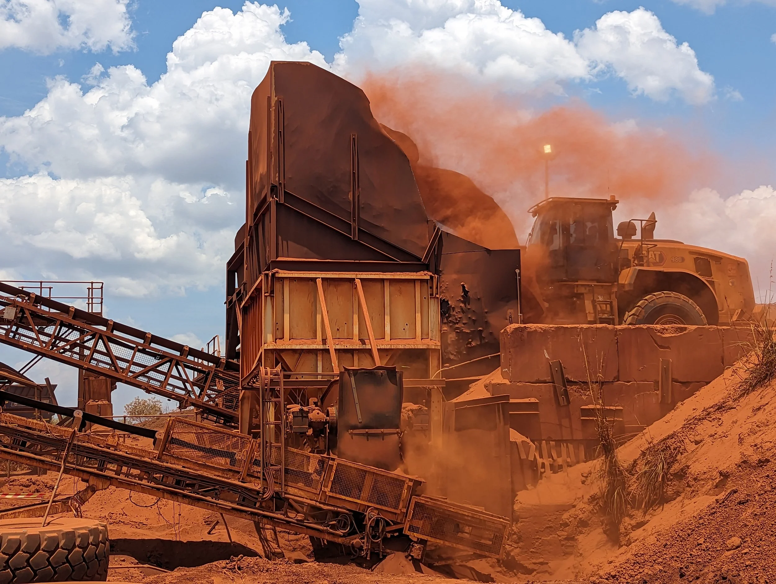 Loader empties bauxite ore into hopper for processing