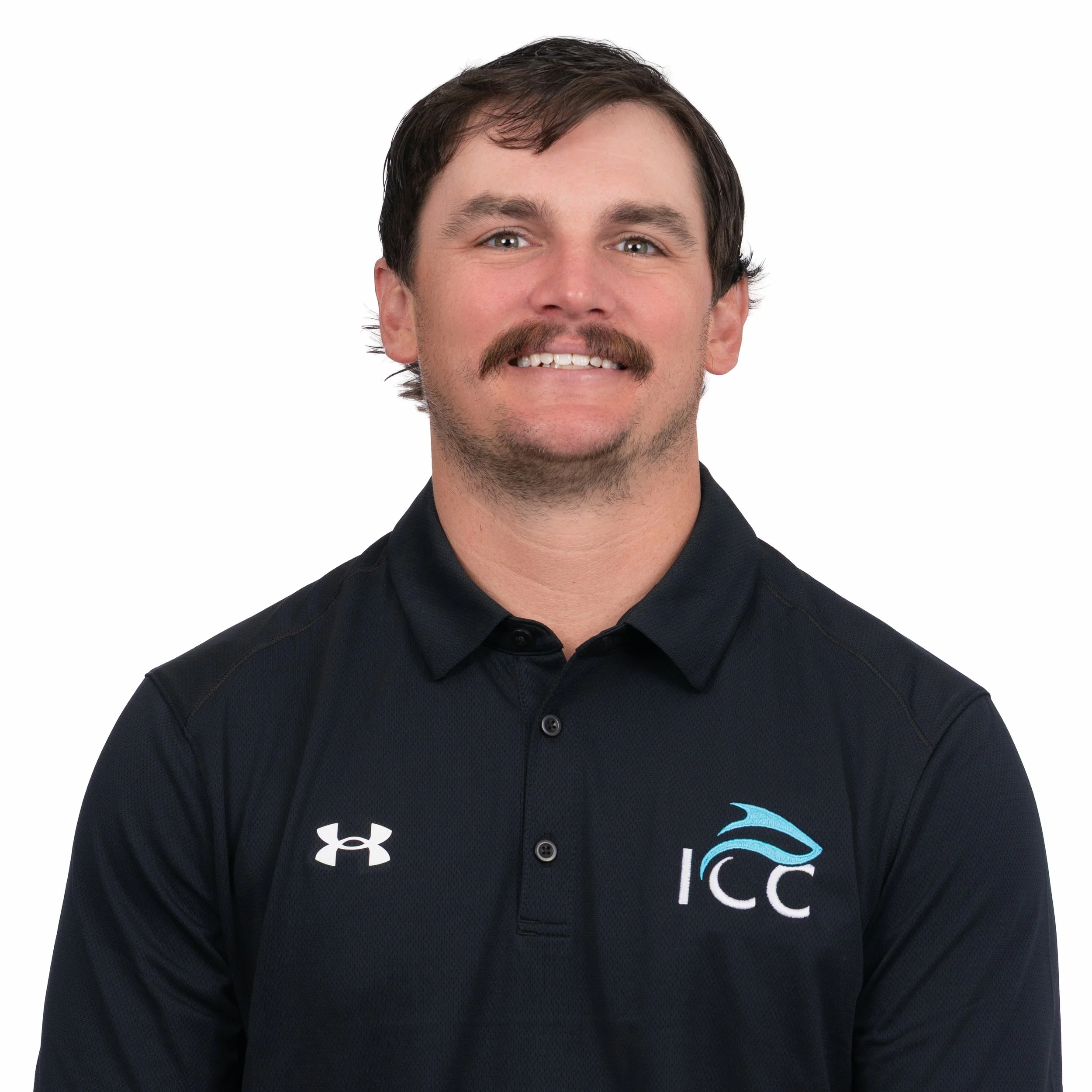 Man wearing a blue polo shirt smiling against a white background.