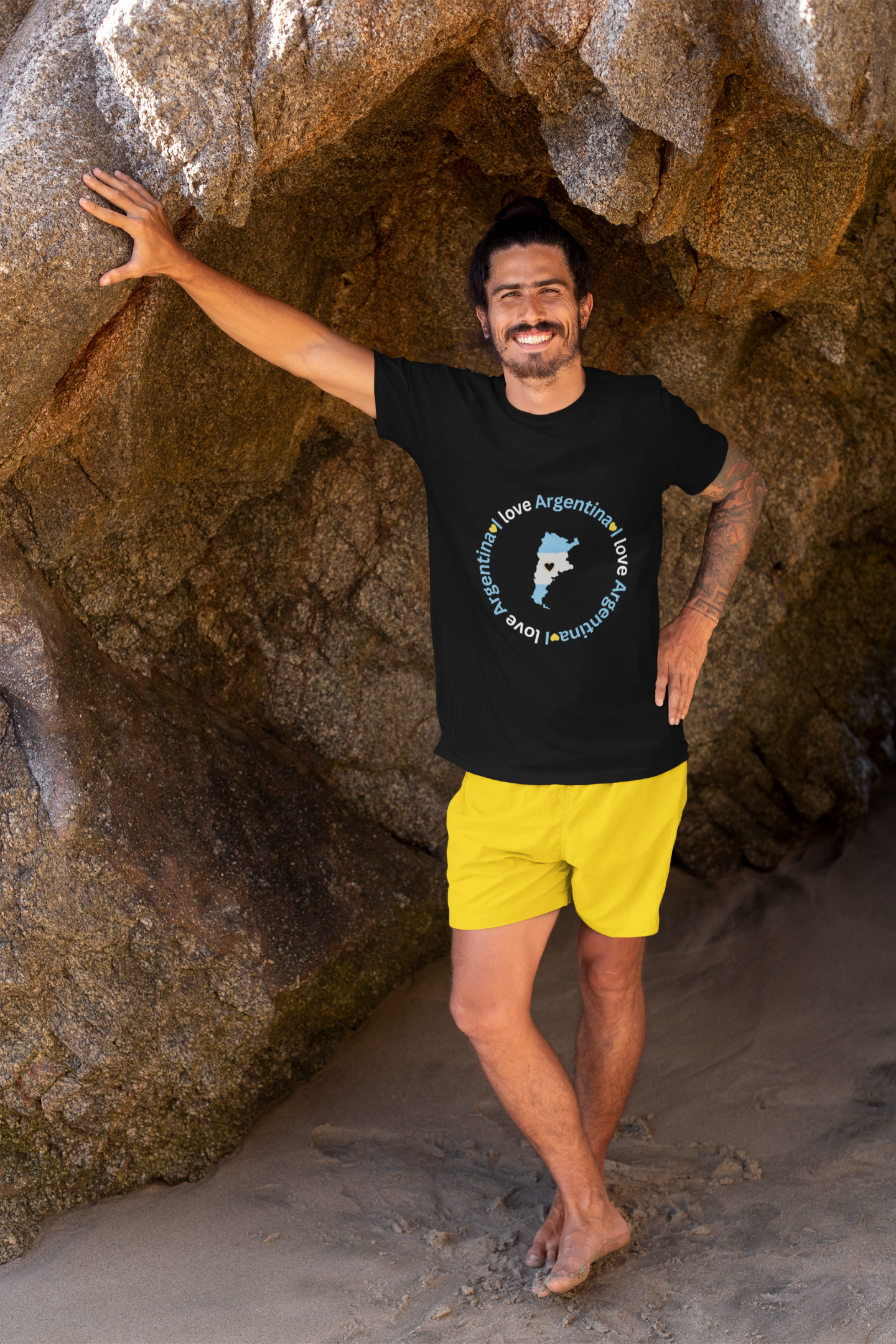 t-shirt-mockup-of-a-tattooed-man-leaning-against-a-big-rock-by-the-beach-26804.png
