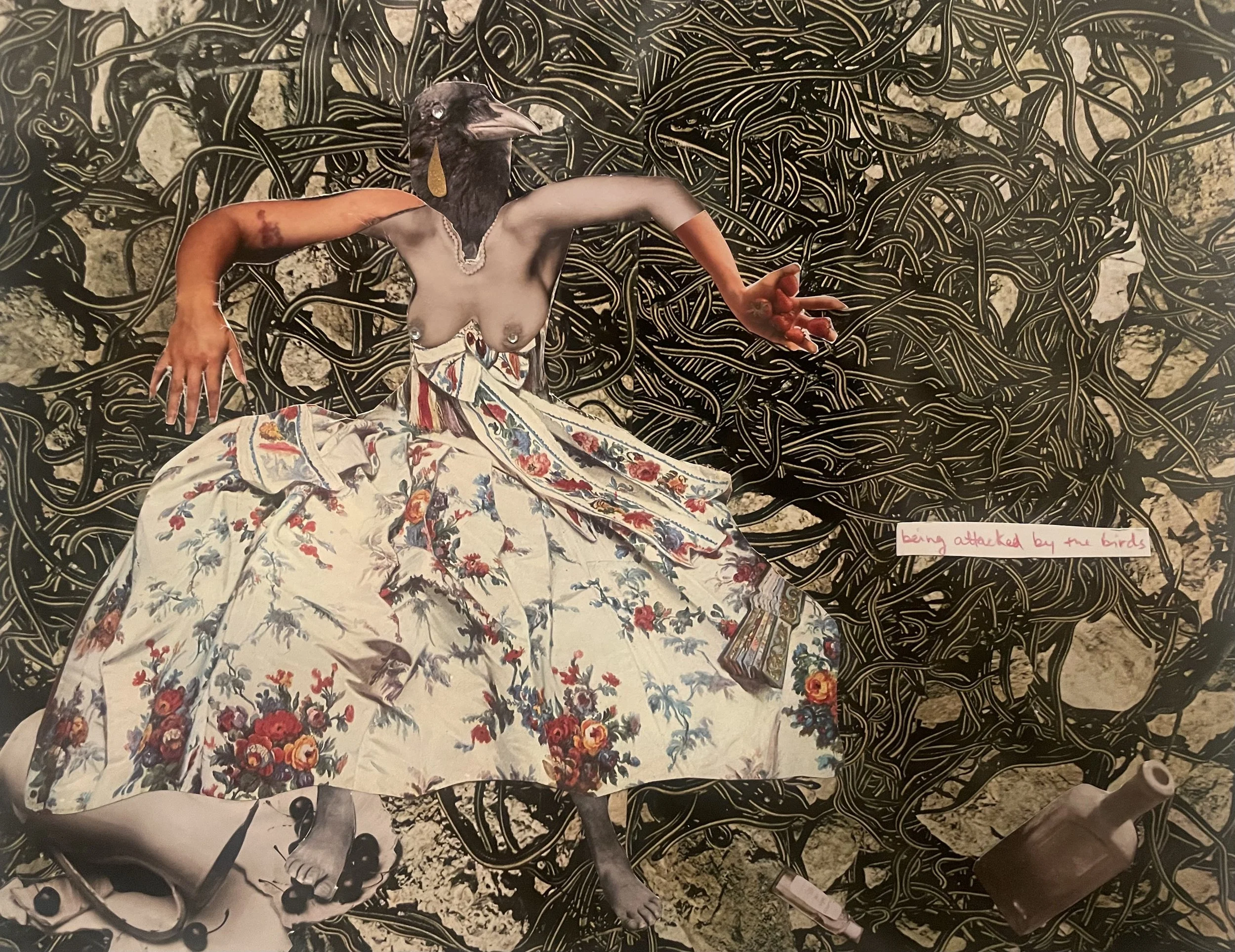 Surreal artwork featuring a humanoid figure with a bird's head, a human torso and arms, wearing a floral skirt. The background is a tangle of black lines with a textured look. A small text reads "being attacked by the birds" and a bottle is also visible.