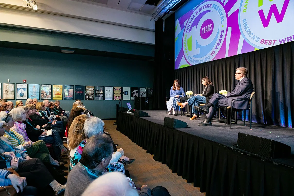 Panel discussion at the Mirage Writers Festival celebrating 10 years, with four speakers on stage and an audience watching.