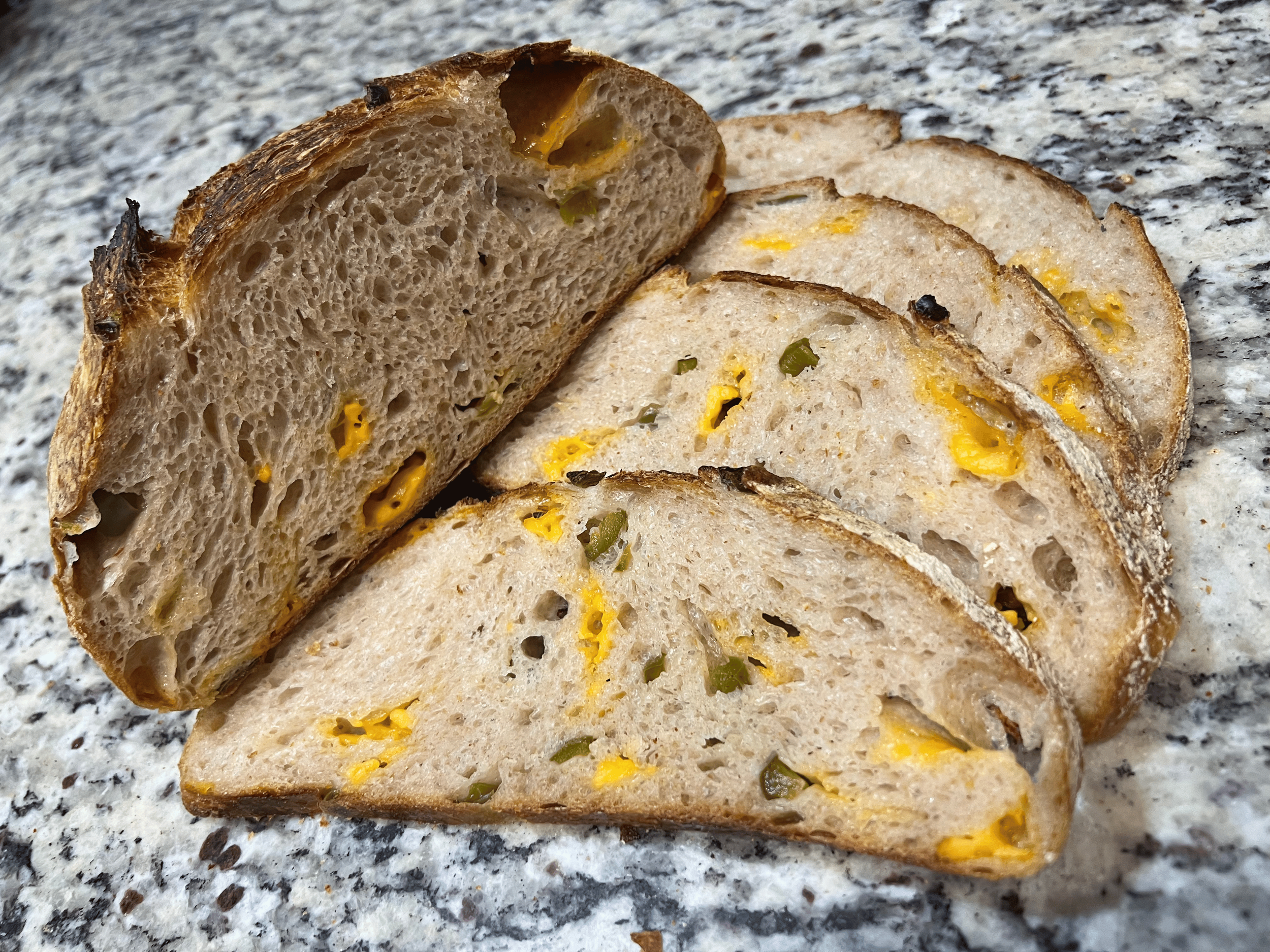 Texas jalapeño cheddar batard by Gertrudis Panem Vitas, with melted cheese and sliced jalapeños baked into the crust