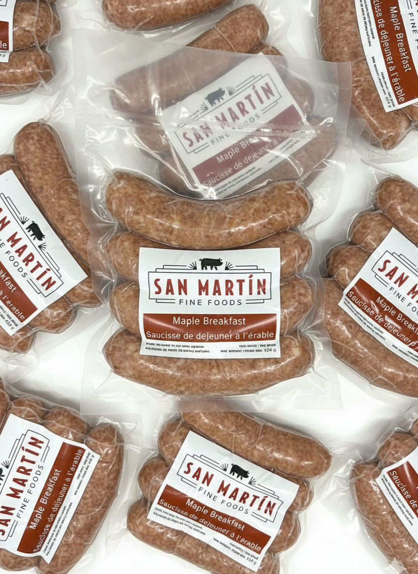Rows of raw sausages laid out on a flat surface, with some coiled sausages in the background.