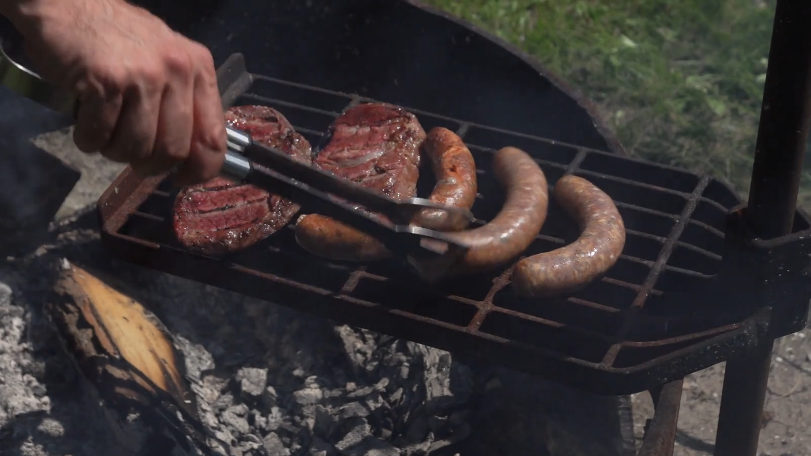 Grilled chorizo sausages on a grill with a logo for El Chorizo Latino in the upper corner.
