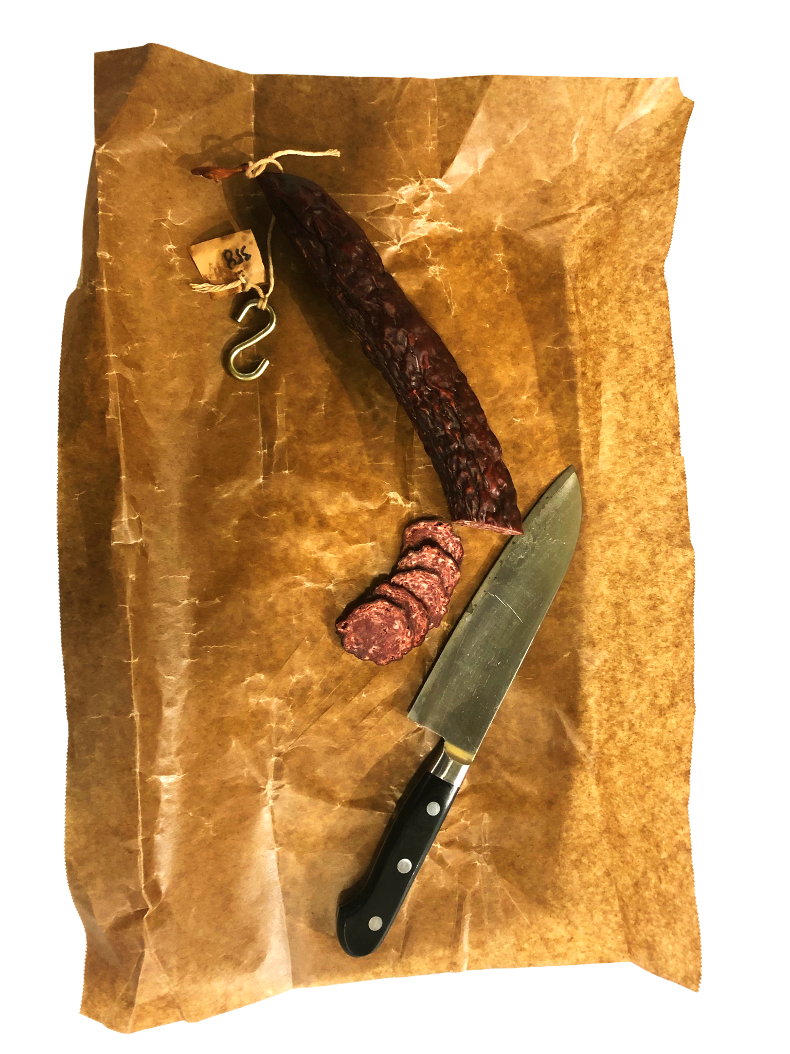 Dried sausage, sliced sausage, a kitchen knife, and a hanging hook on brown parchment paper.