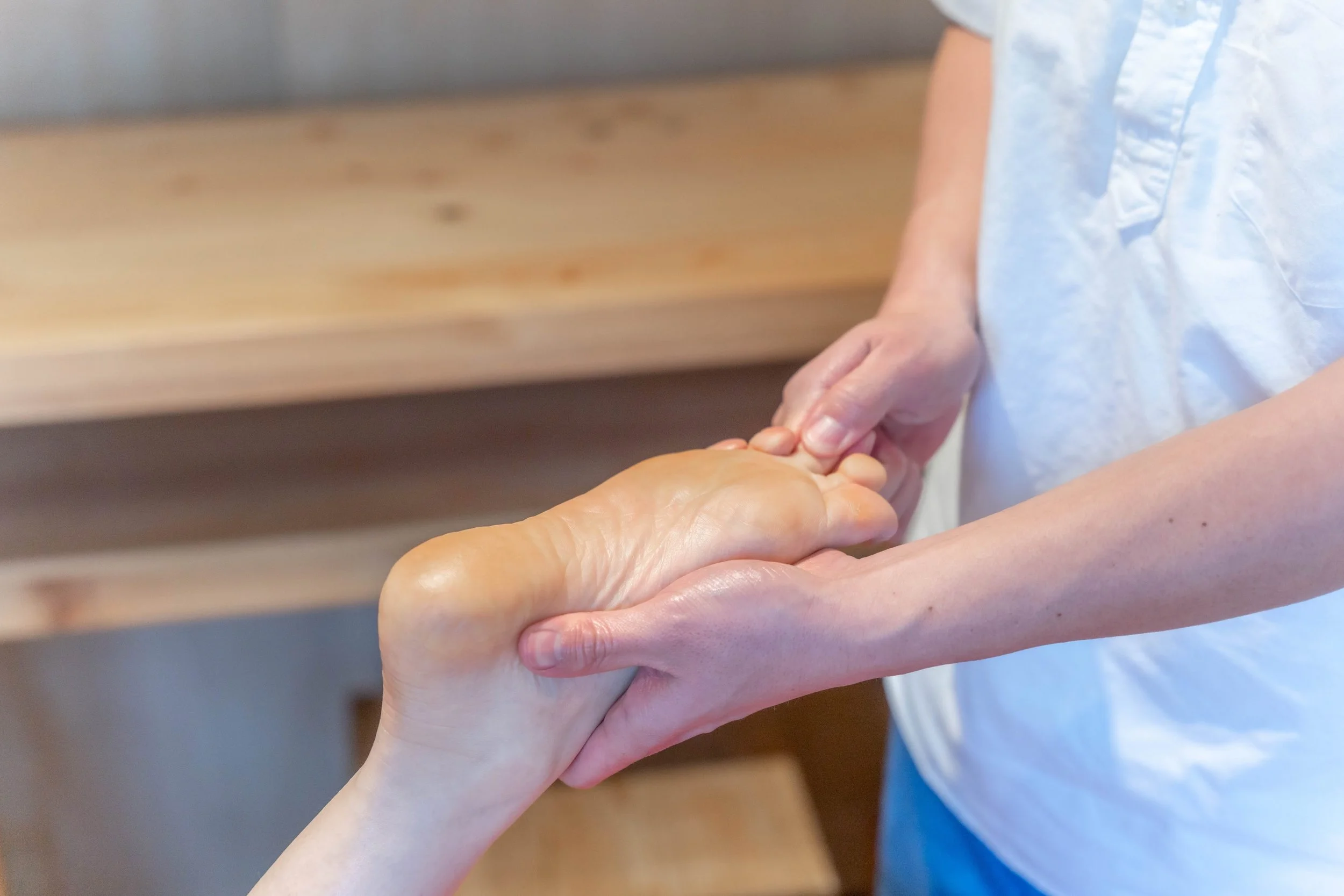 足の指圧マッサージを受けている人の下足のクローズアップ。