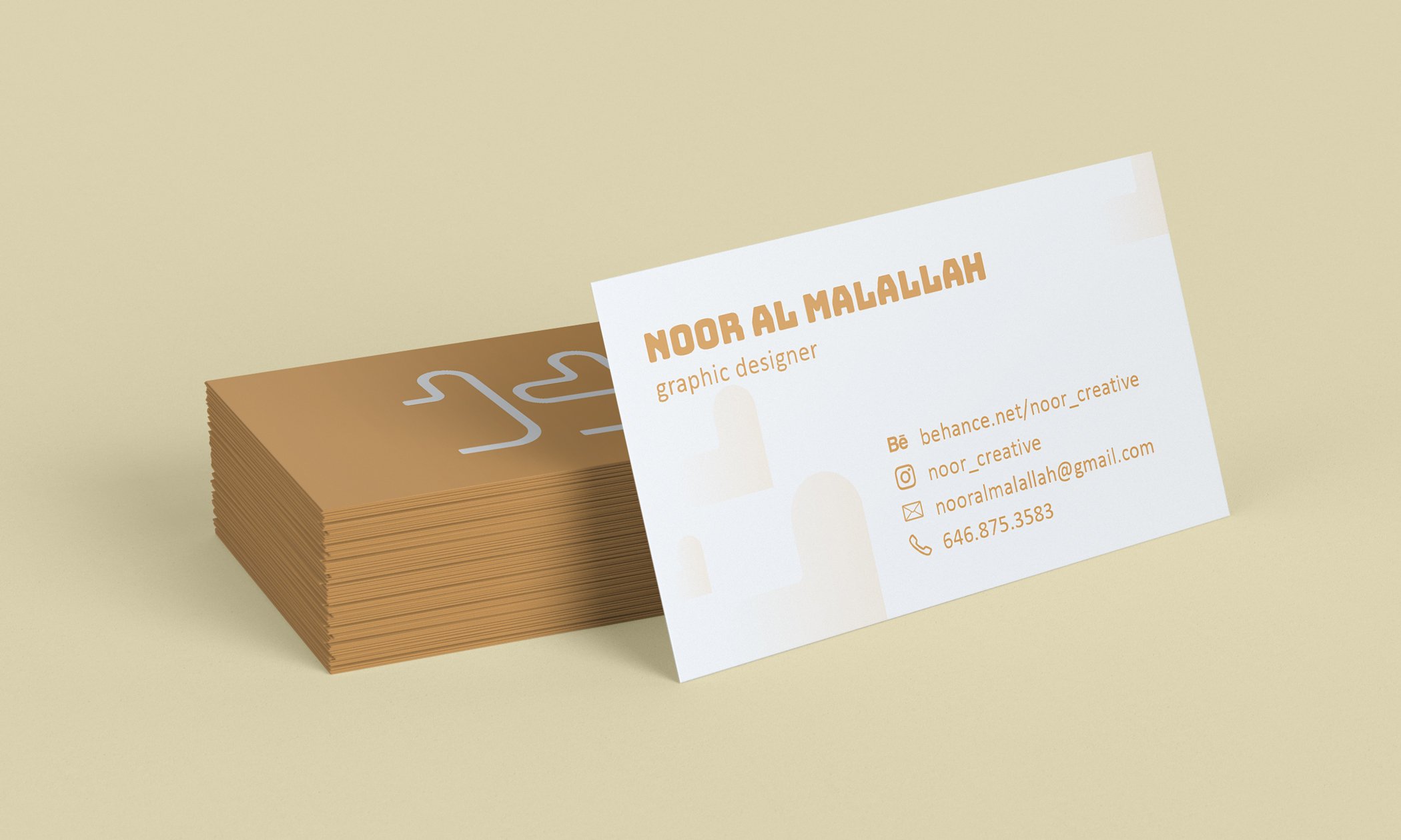 Stack of brown business cards with one card displaying contact details for "Noor Al Malallah, Graphic Designer."