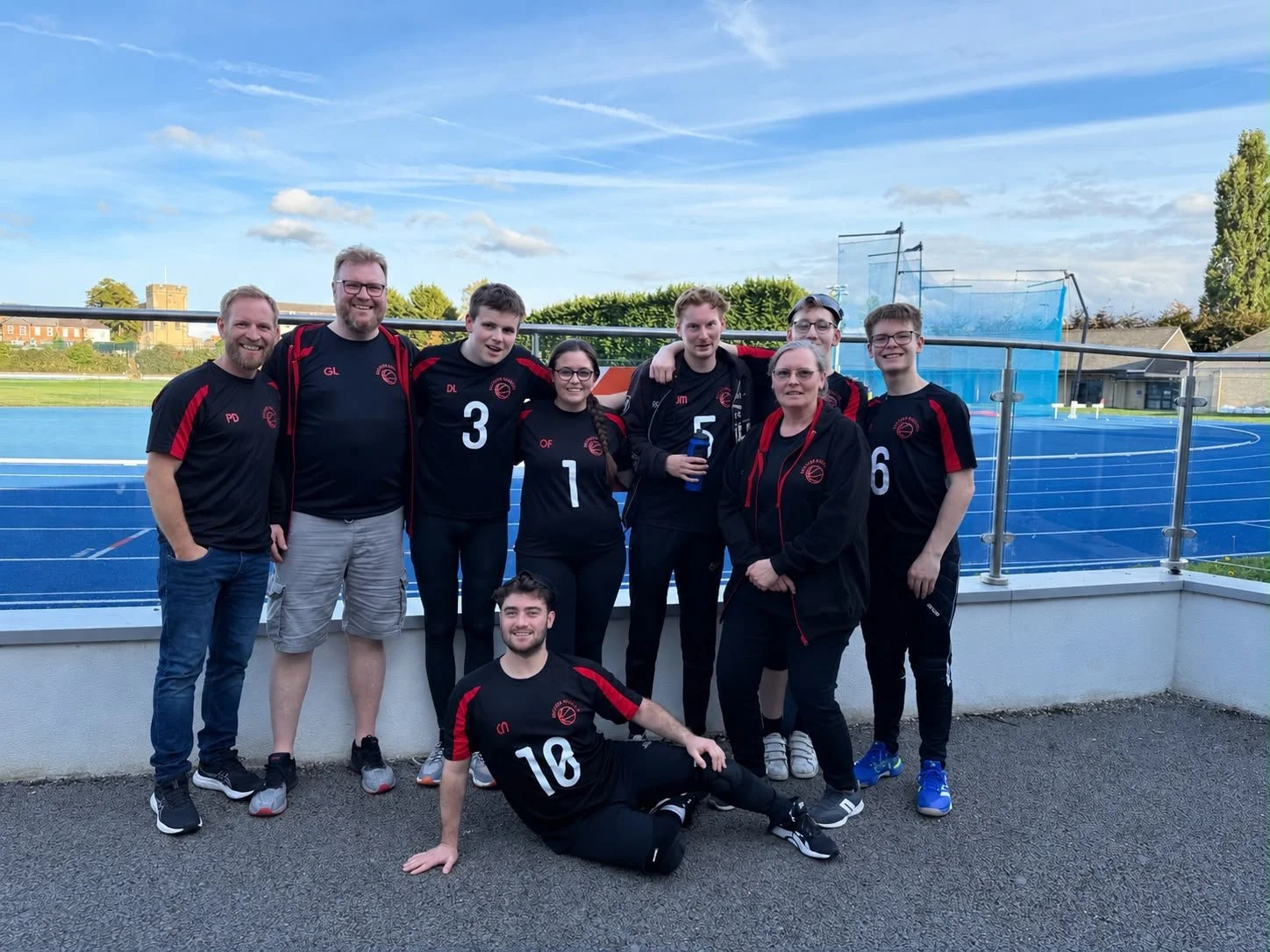The Watford Wizards players and support team smile for a group photo beside the blue athletics track at Iffley Road Sports Centre in Oxford. 