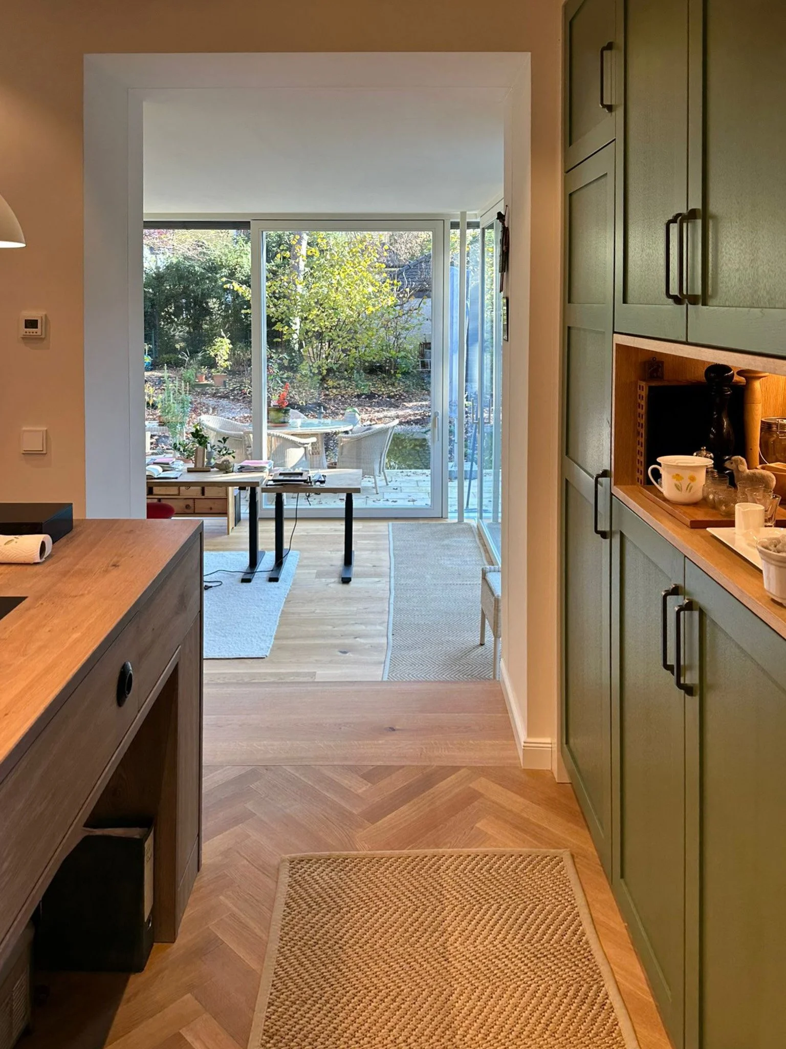 Blick aus der Küche in den lichtdurchfluteten Anbau mit Bezug zum Garten.