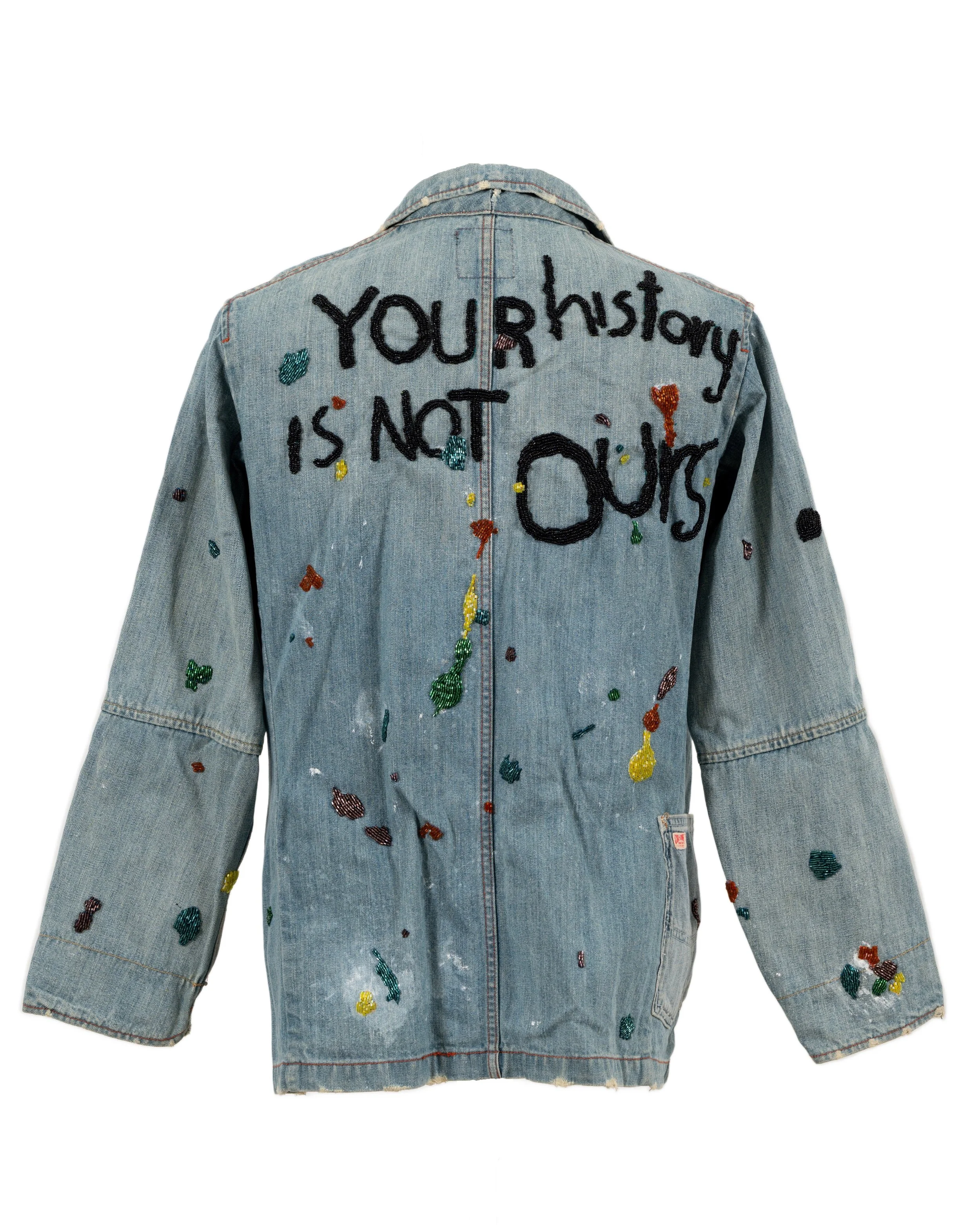 Jakkai Siributr, YOUR HISTORY IS NOT OURS, 2022, glass and plastic beads on a paint-splattered vintage Japanese denim jacket, 76 × 45cm. Donated by the artist and Flowers Gallery.