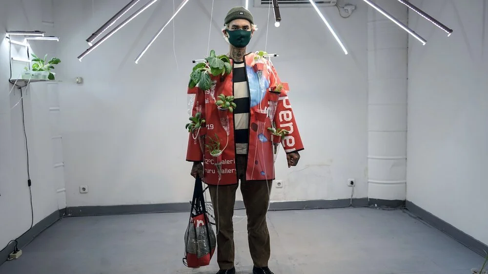 MG Pringgotono, Shifting Ecosystem, 2020, installation of upcycled clothes and aquaponics systems, from used plastic banners, fishes, bok choys, water, irrigation pump, LED light, human. Images courtesy of Serrum Arthandling/Gudskul.