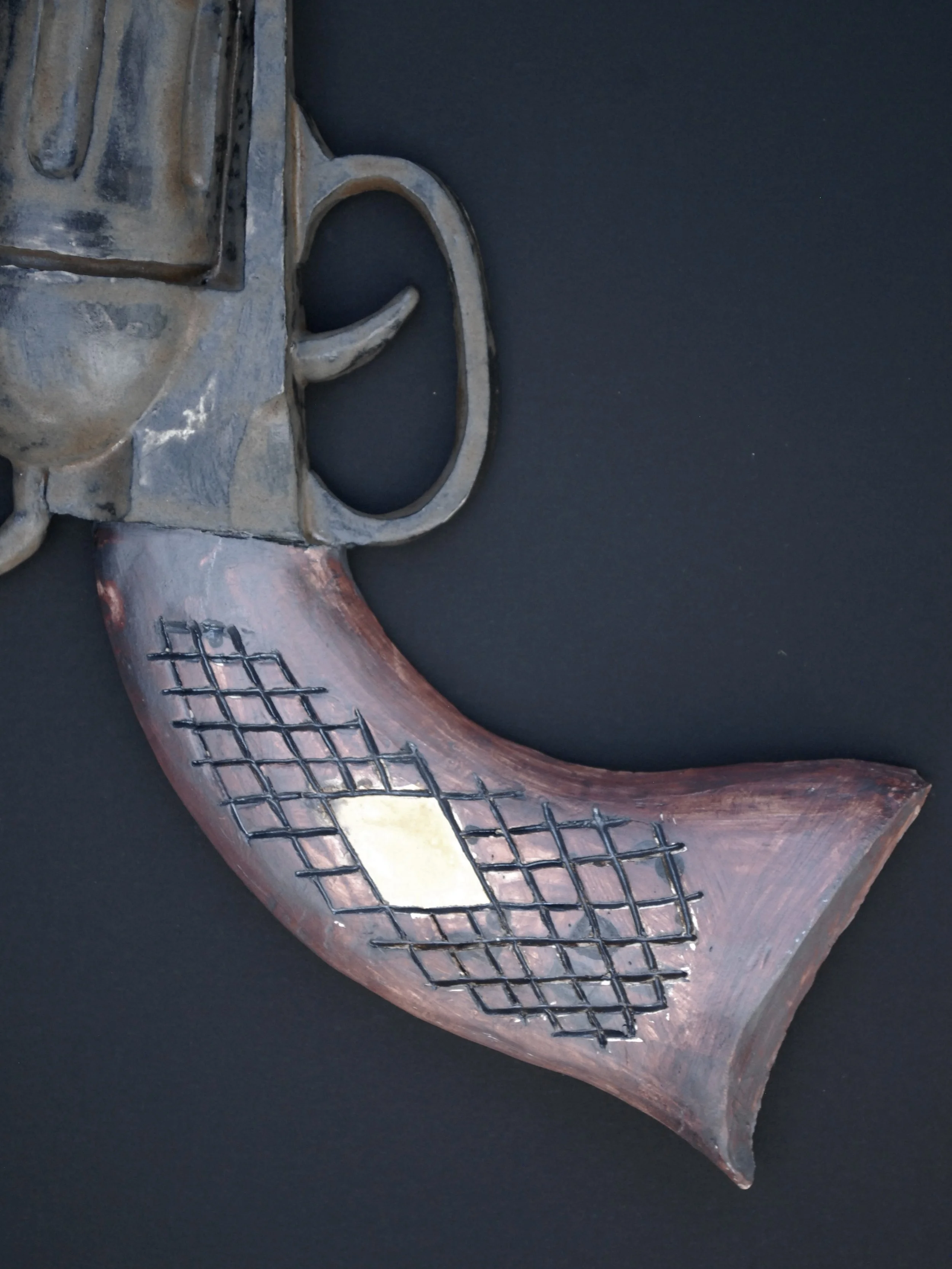 Image shows a ceramic, antique style revolver with a bent barrel. The gun has a dark weathered finish on the metal contrasting with the painted wooden style grip