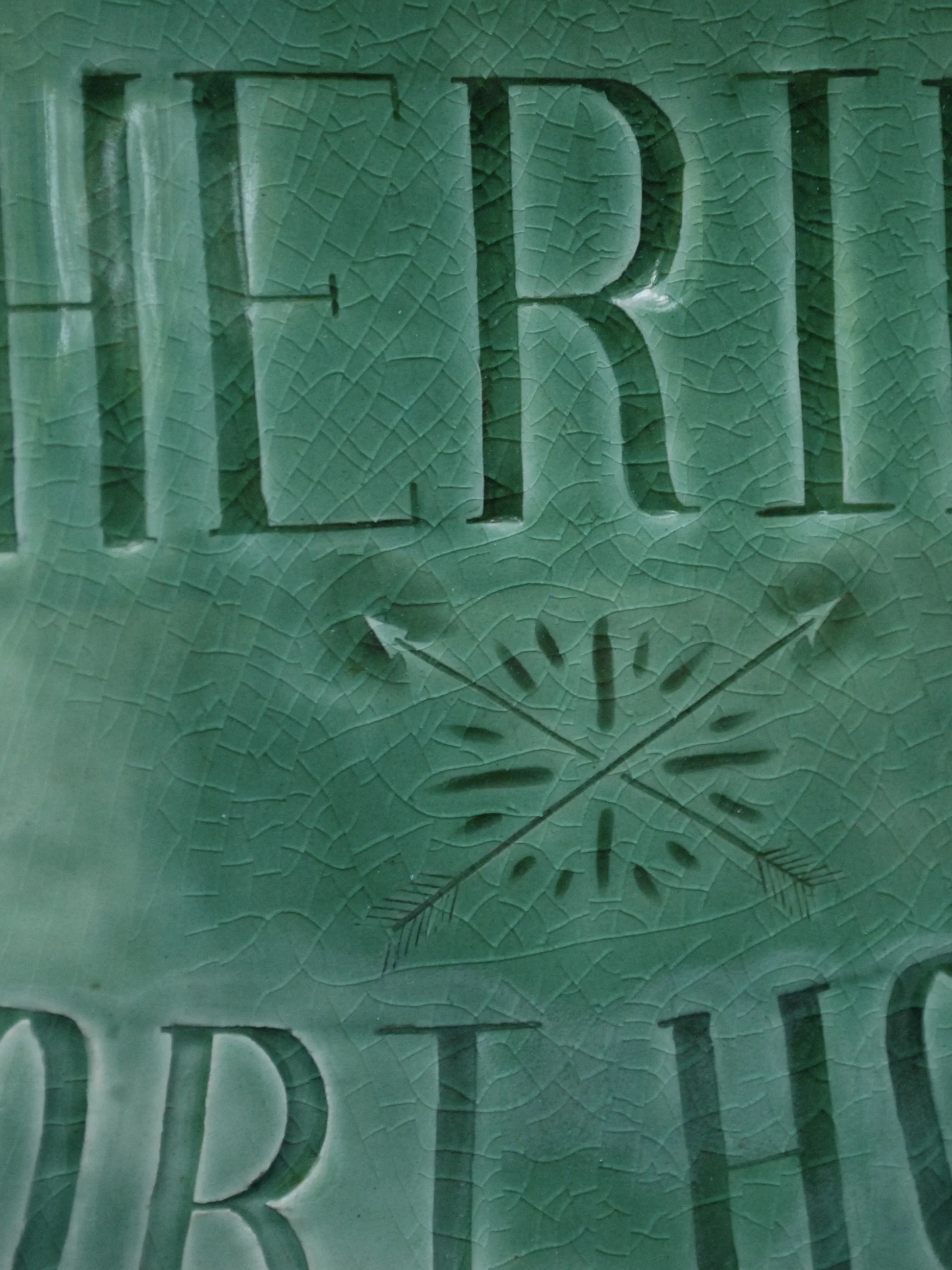 Image shows a large shield shaped badge, with the words 'Deputy Sheriff, Fort hope' etched across. It is finished with a greeny blue crackle glaze finish with a ridged edge.