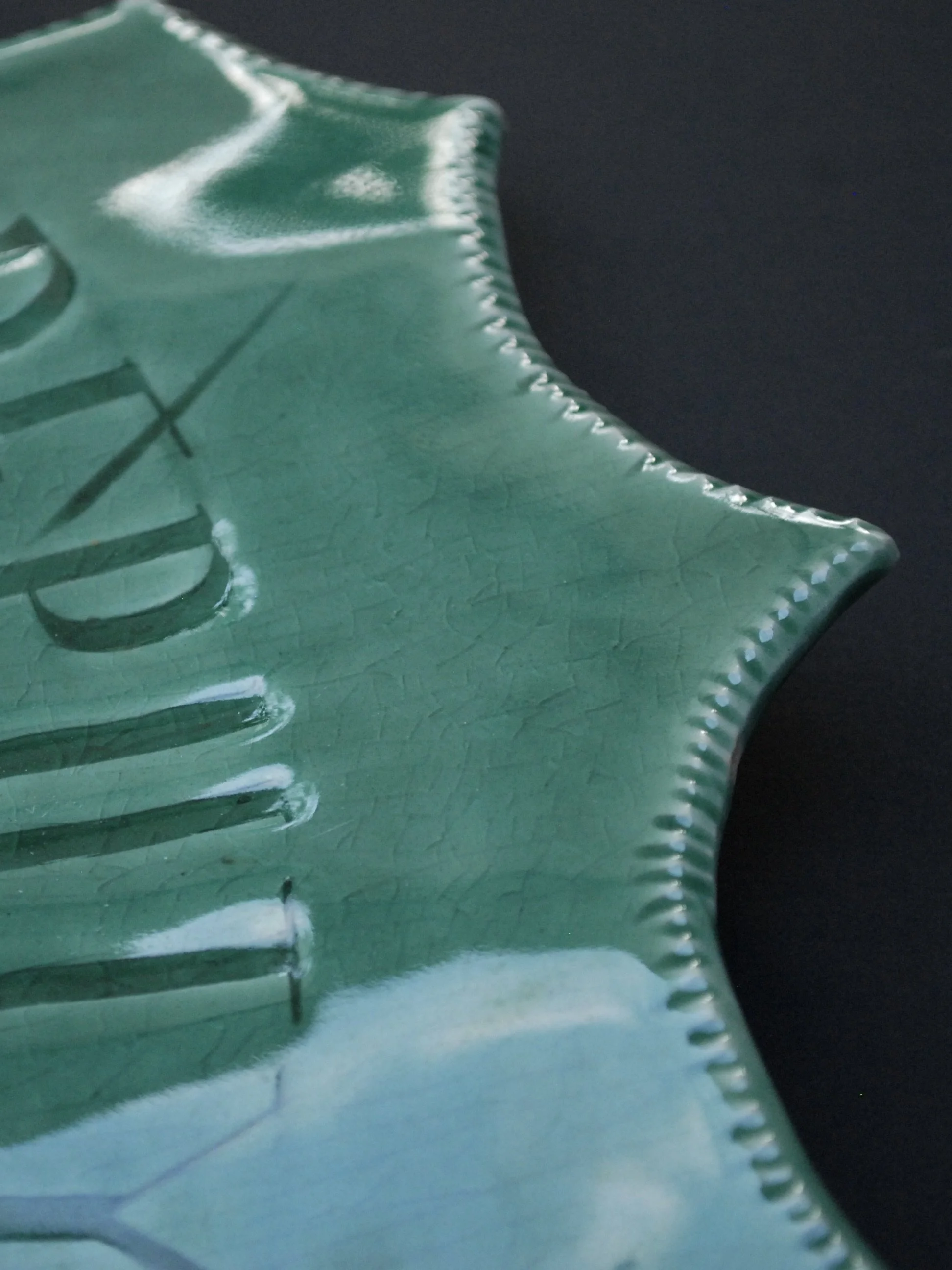 Image shows a large shield shaped badge, with the words 'Deputy Sheriff, Fort hope' etched across. It is finished with a greeny blue crackle glaze finish with a ridged edge.