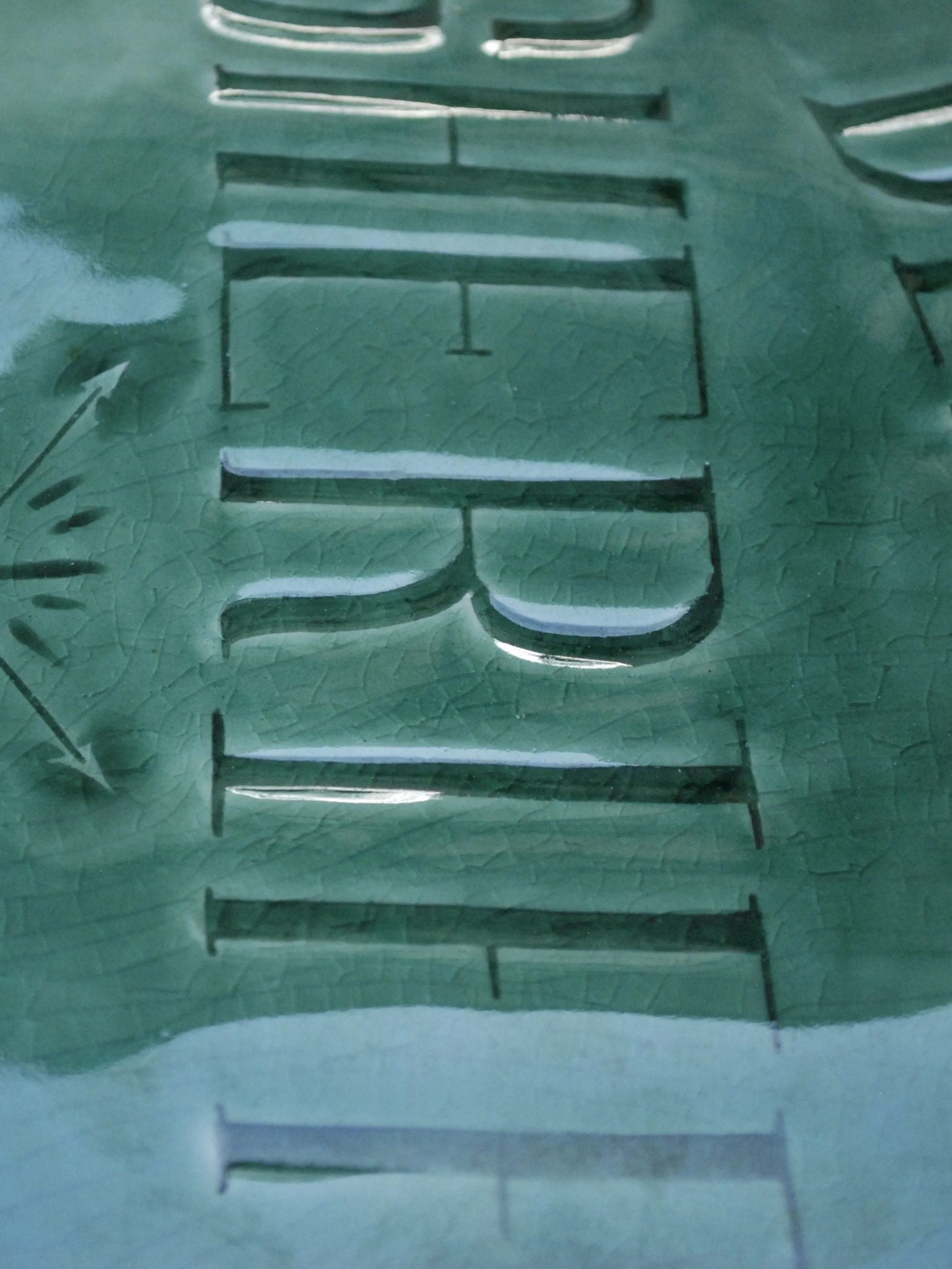 Image shows a large shield shaped badge, with the words 'Deputy Sheriff, Fort hope' etched across. It is finished with a greeny blue crackle glaze finish with a ridged edge.