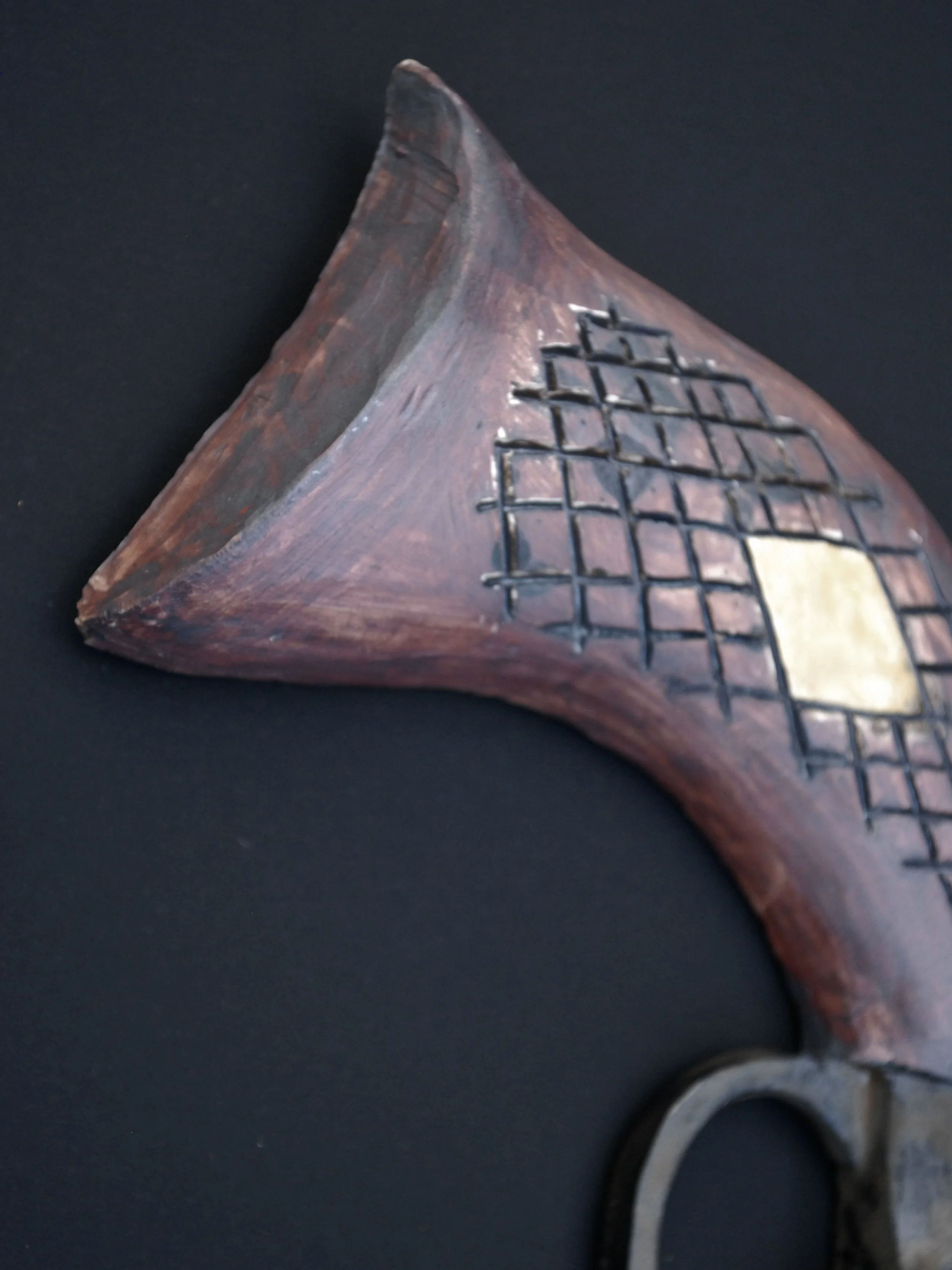 Image shows a ceramic, antique style revolver with a bent barrel. The gun has a dark weathered finish on the metal contrasting with the painted wooden style grip