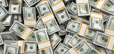 Stacks of U.S. hundred-dollar bills spread across a surface.