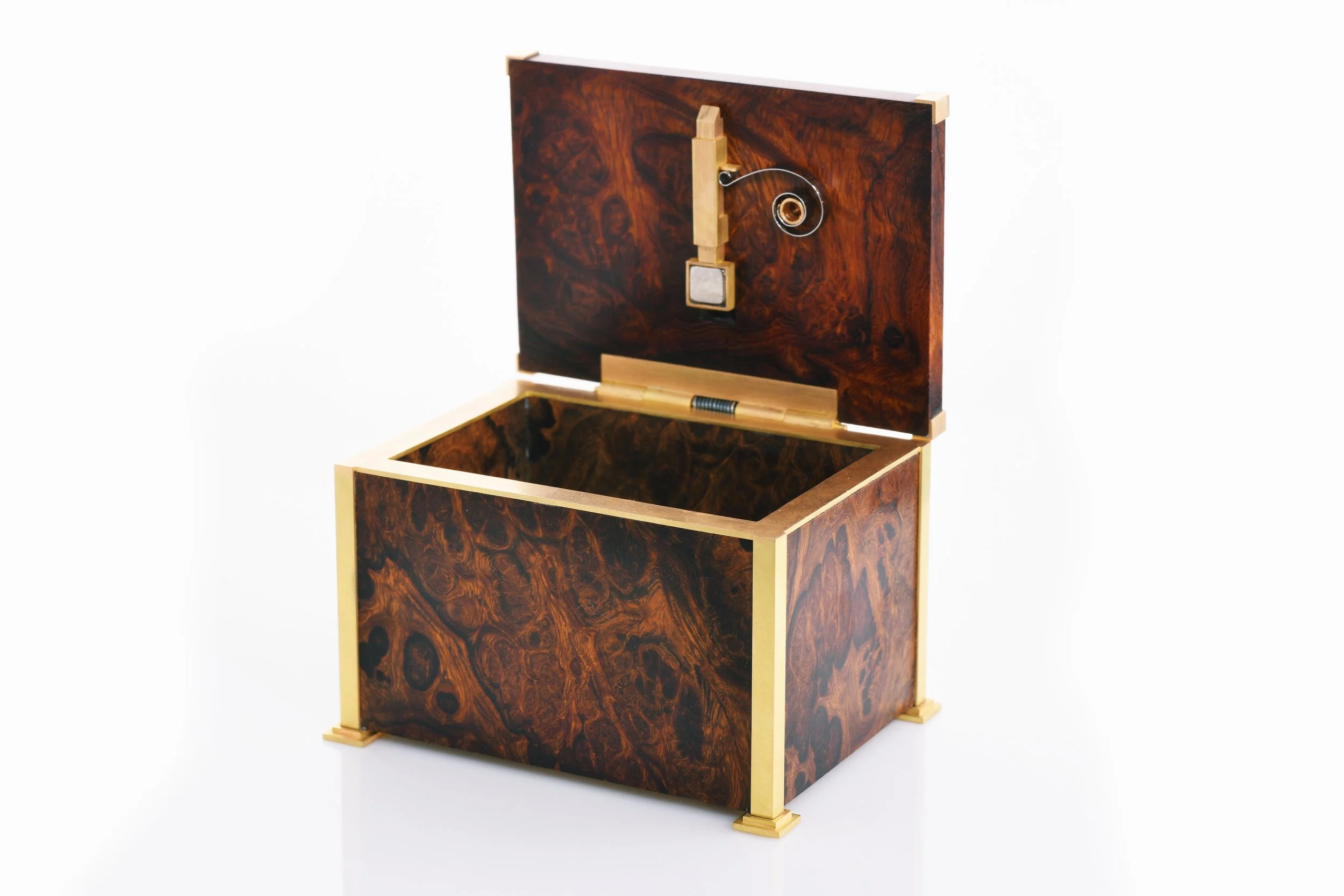 Ein dekorativer Holzkasten mit offenem Deckel und mechanischen Komponenten.