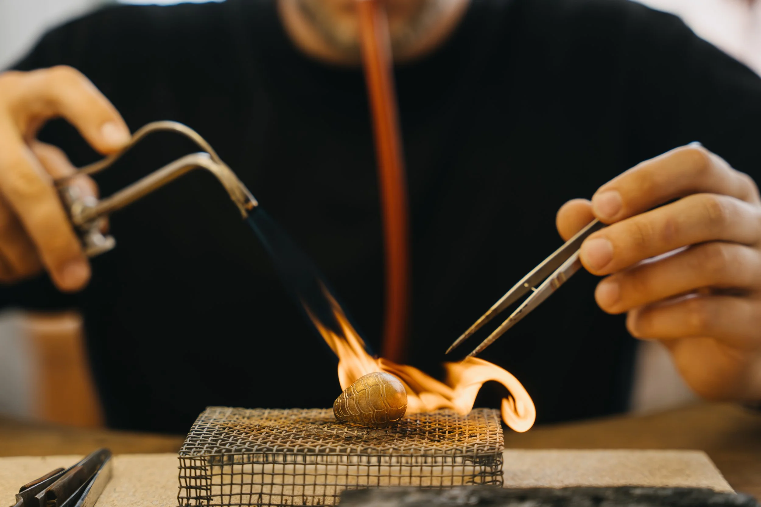 Ein Handwerker schmiedet einen goldenen Ring im Schmelzofen