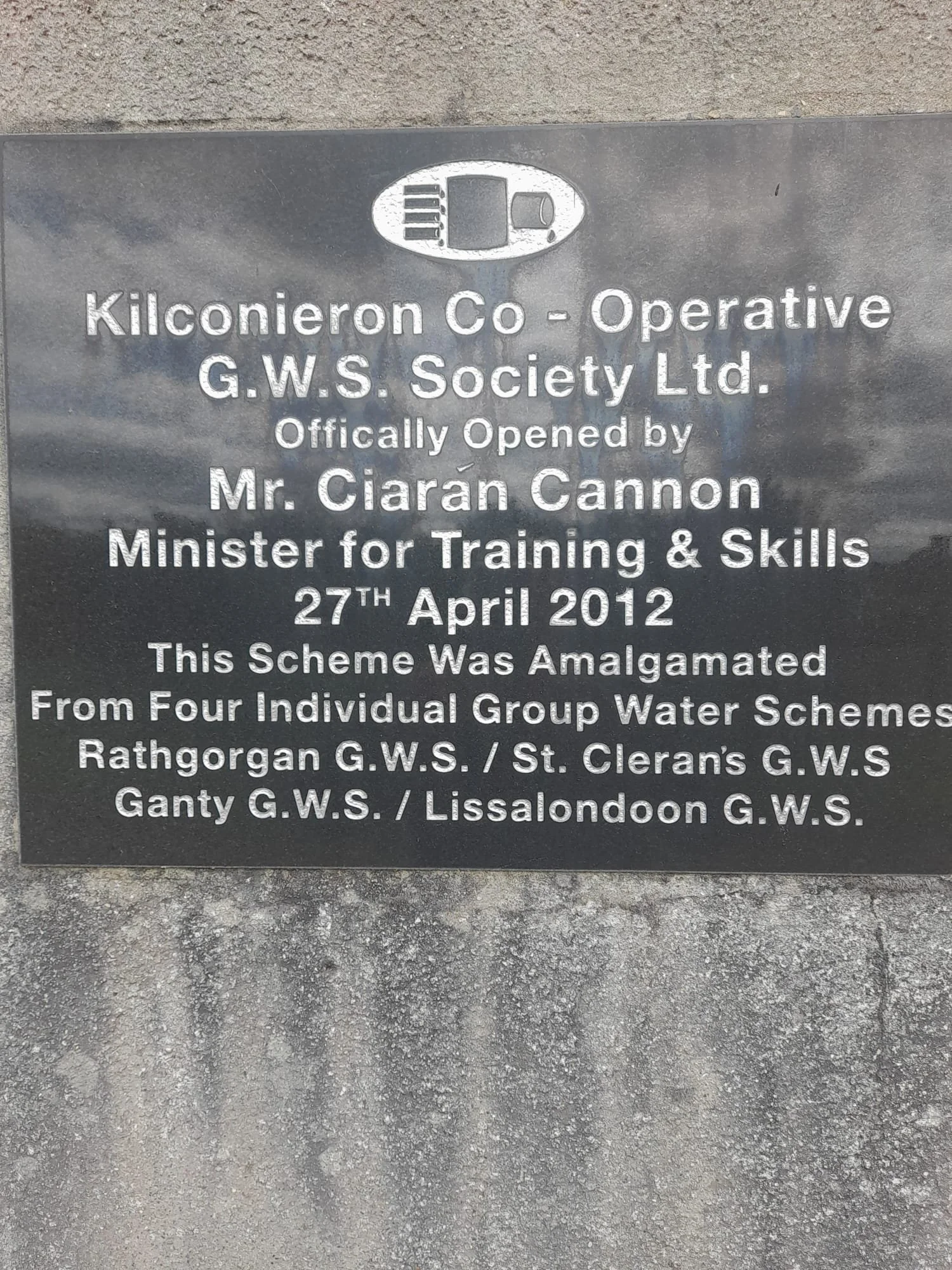Plaque for Kilconieron Co-Operative G.W.S. Society Ltd, opened by Mr. Ciarán Cannon, Minister for Training & Skills, on April 27, 2012, mentioning amalgamation from four group water schemes.