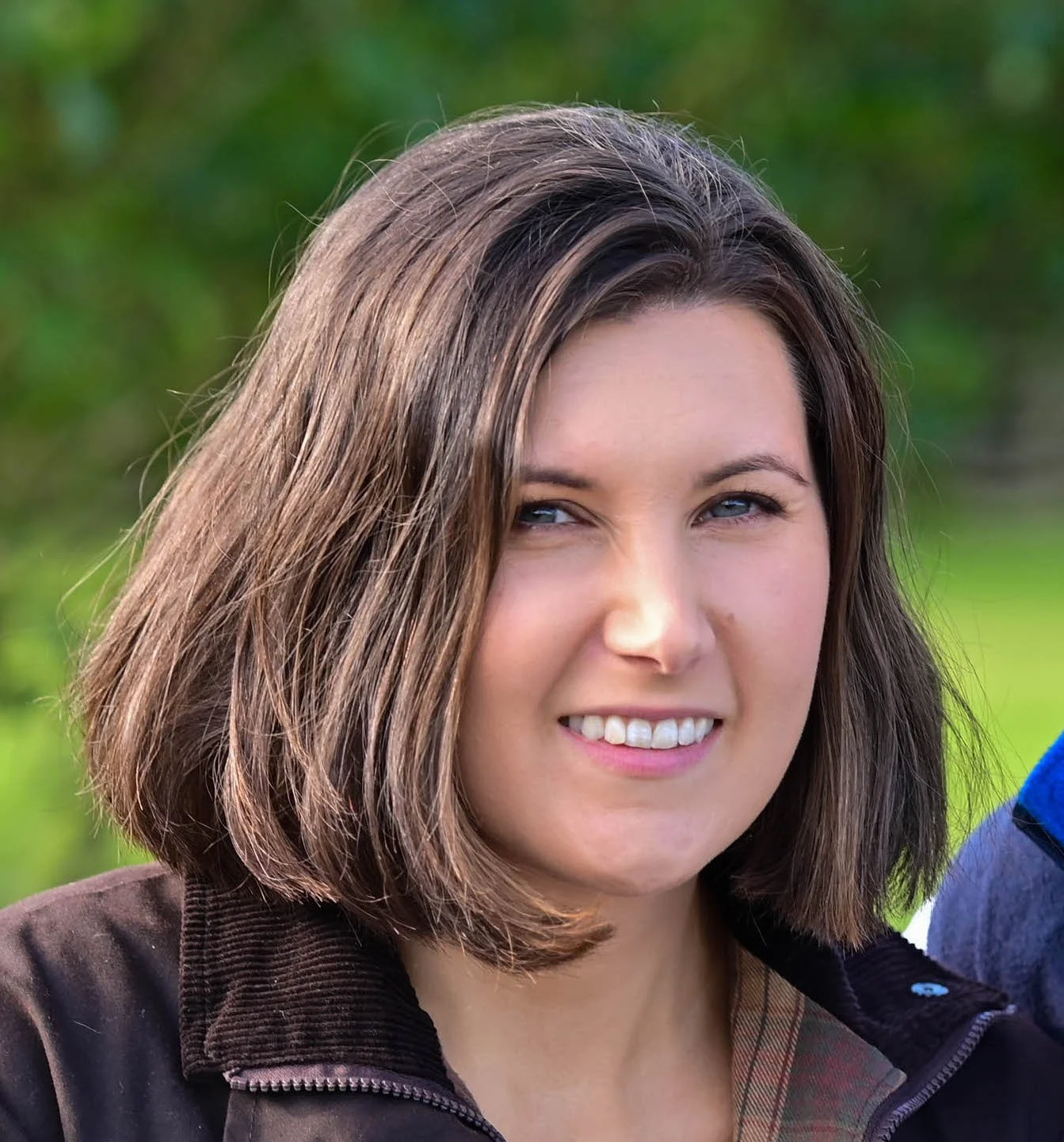headshot of Amy. In the photo Amy has shoulder-length brown hair. Except this photo was taken years ago and now it's halfway down her back. Really need to get more photo. She looks at the camera, smiling.