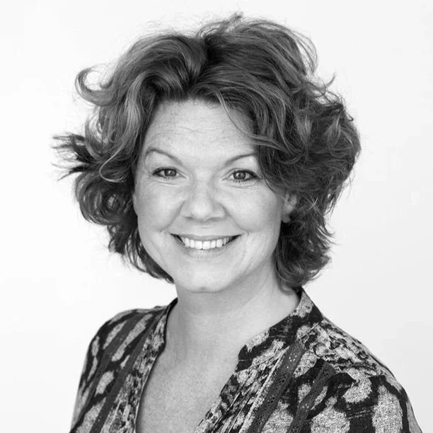 Svartvitt studioporträtt av Cecilia Davidsson hon ler. 