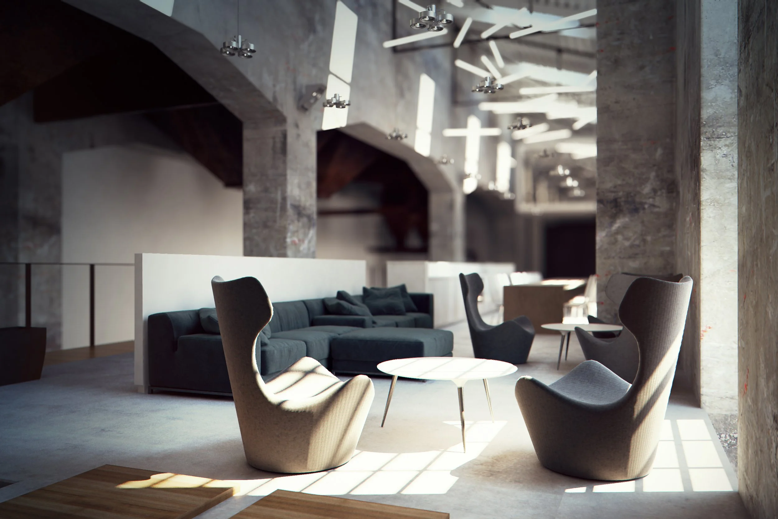 Modern industrial-style lounge area with gray armchairs, a large sectional sofa, and round coffee tables in a concrete-walled space with contemporary lighting.
