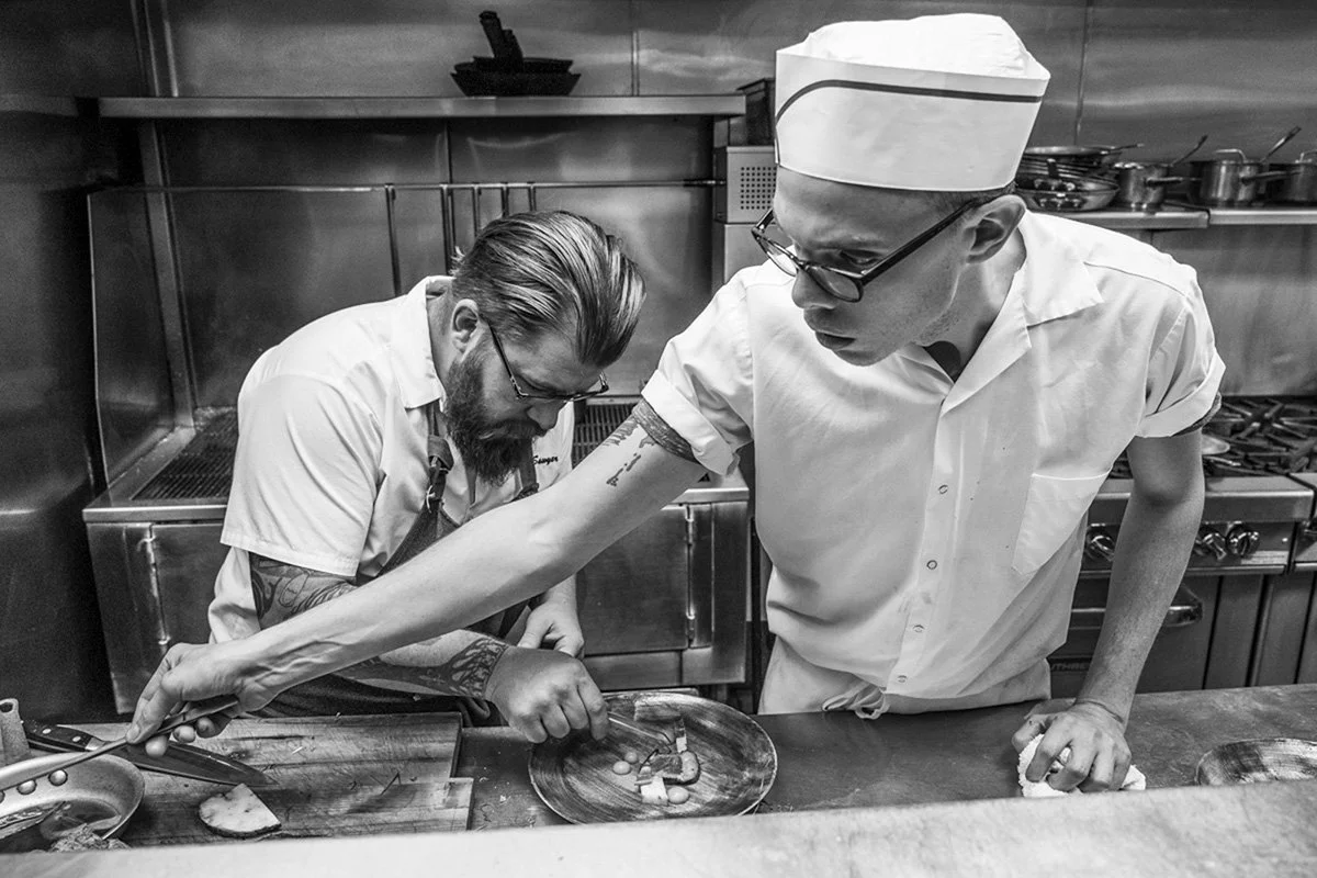 two chefs in a kitchen cooking food