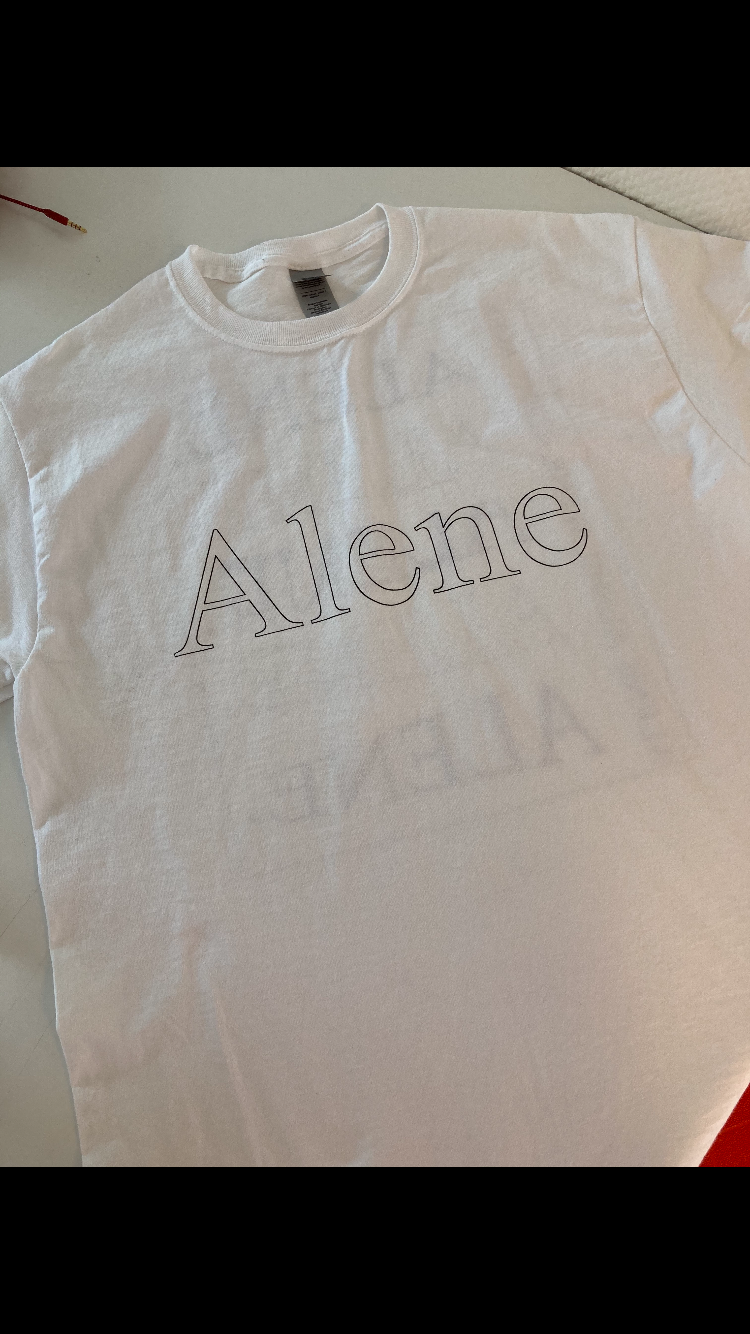 Hvitt t-skjorte med teksten "Alene" skrevet i store bokstaver på forsiden.